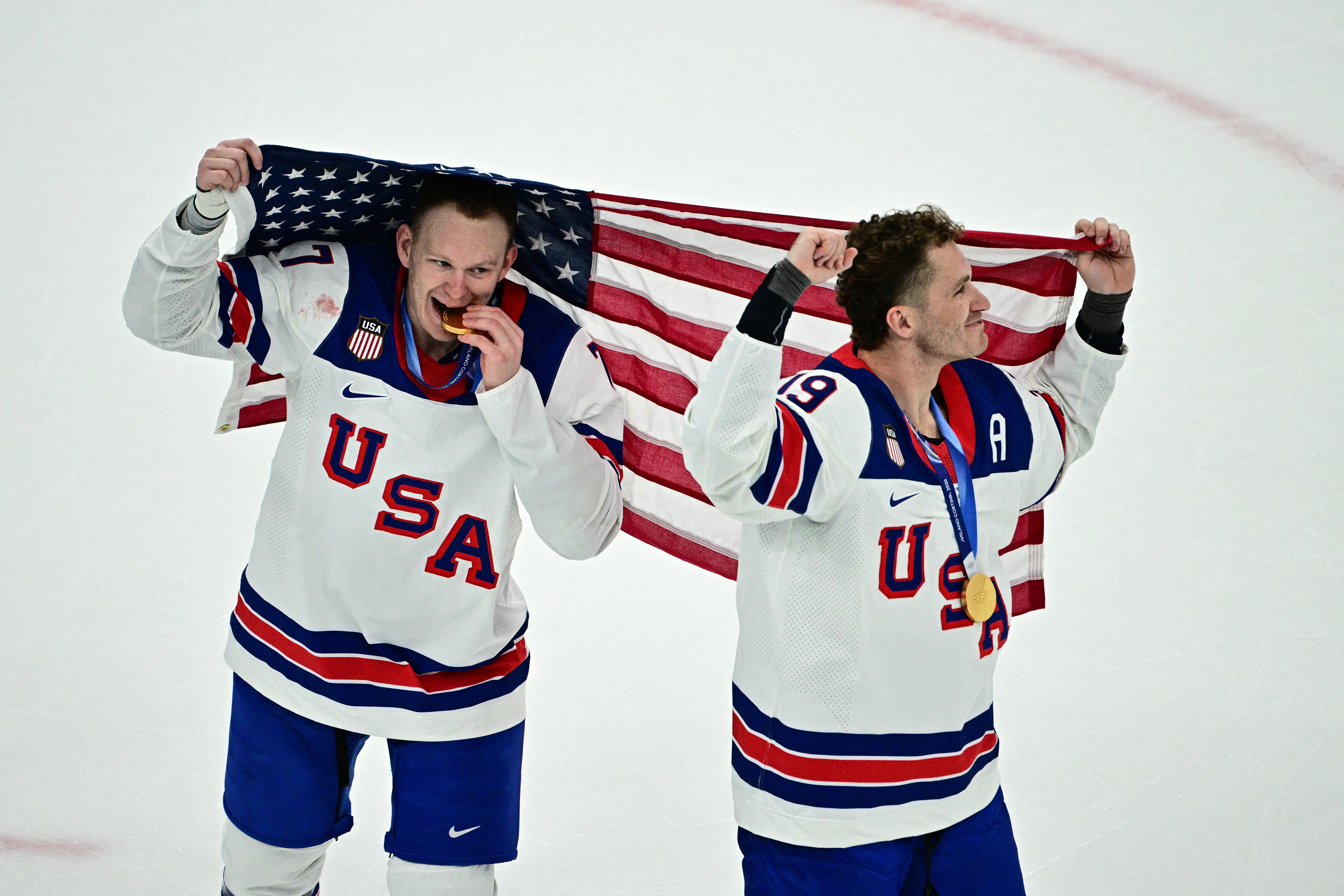 USA's #07 Brady Tkachuk (L) and USA's #19 Matthew Tkachuk celebrate during the medals ceremony of the men's ice hockey event at the Milano Santagiulia Ice Hockey Arena during the Milano Cortina 2026 Winter Olympic Games in Milan, on February 22, 2026. (Photo by JULIEN DE ROSA / AFP)