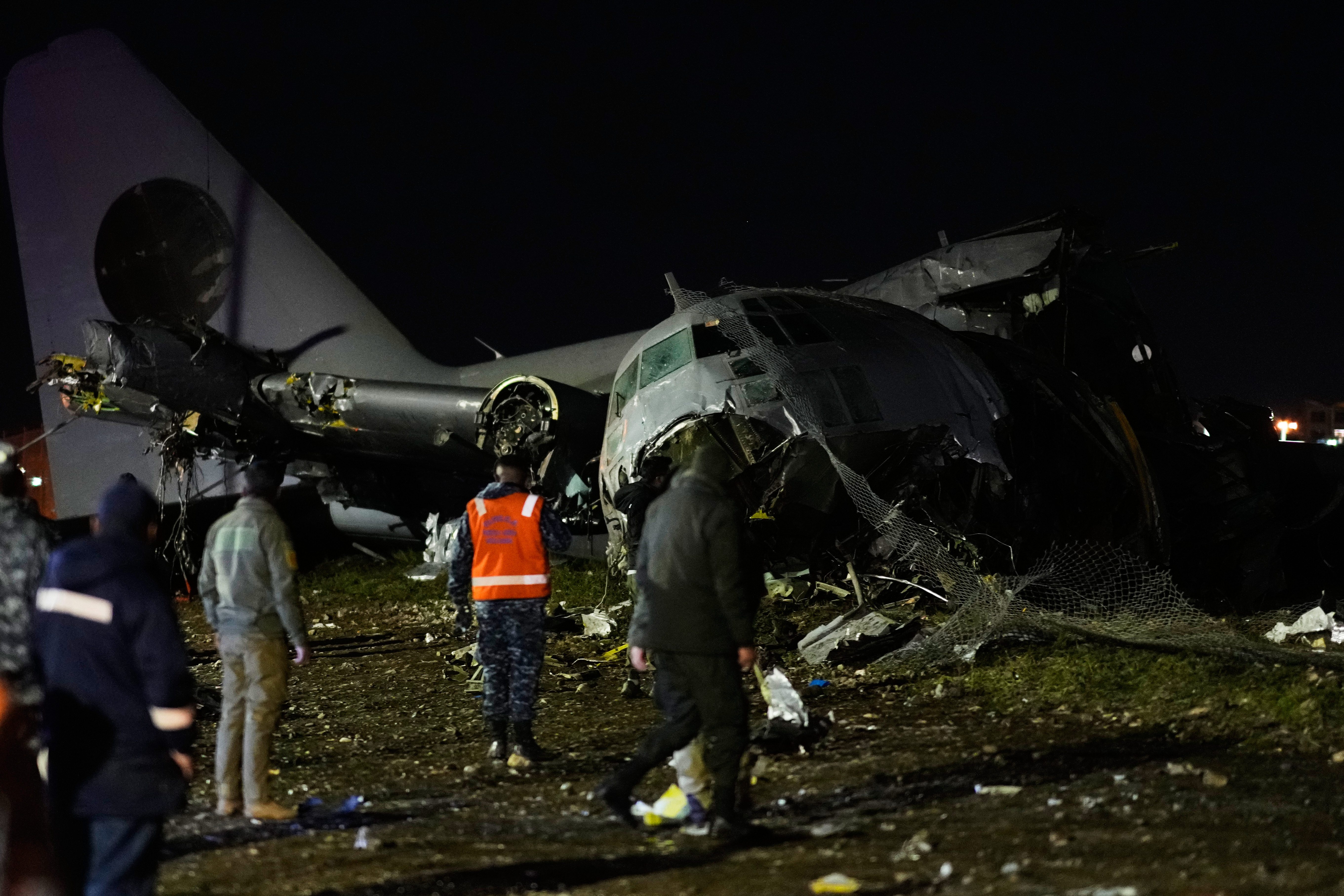 People walk on the scene where a plane crashed on a highway in El Alto, Bolivia, Friday, Feb. 27, 2026. (AP Photo/Juan Karita)