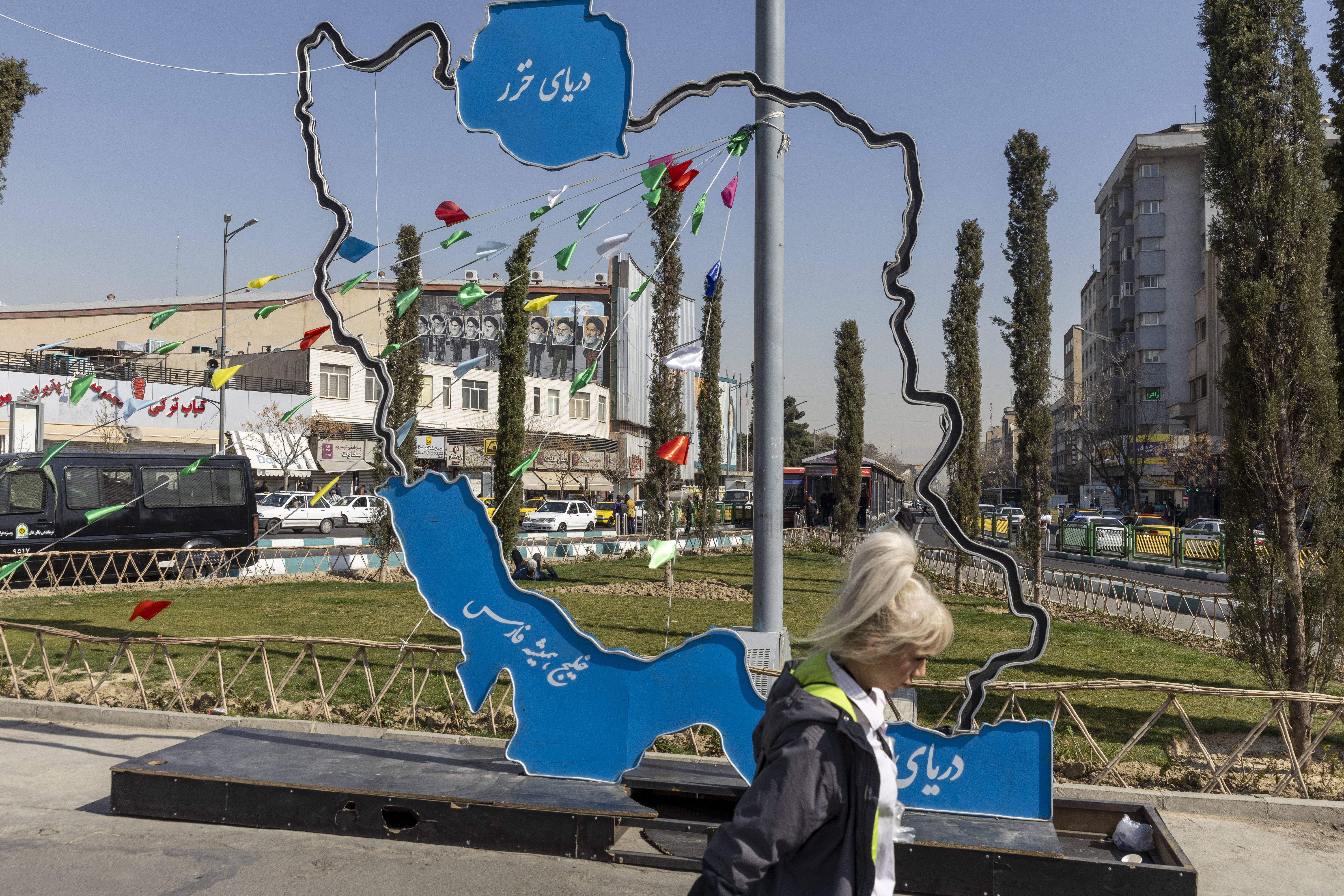 TEHRAN, IRAN - FEBRUARY 21: An Iranian woman walks next to a scuplture of the outline of Iran on a main street in Tehran on February 21, 2026 in Tehran, Iran. In recent weeks, the United States has moved vast numbers of military vessels and aircraft to Europe and the Middle East, heightening speculation that it intended to strike Iran. (Photo by Majid Saeedi/Getty Images)