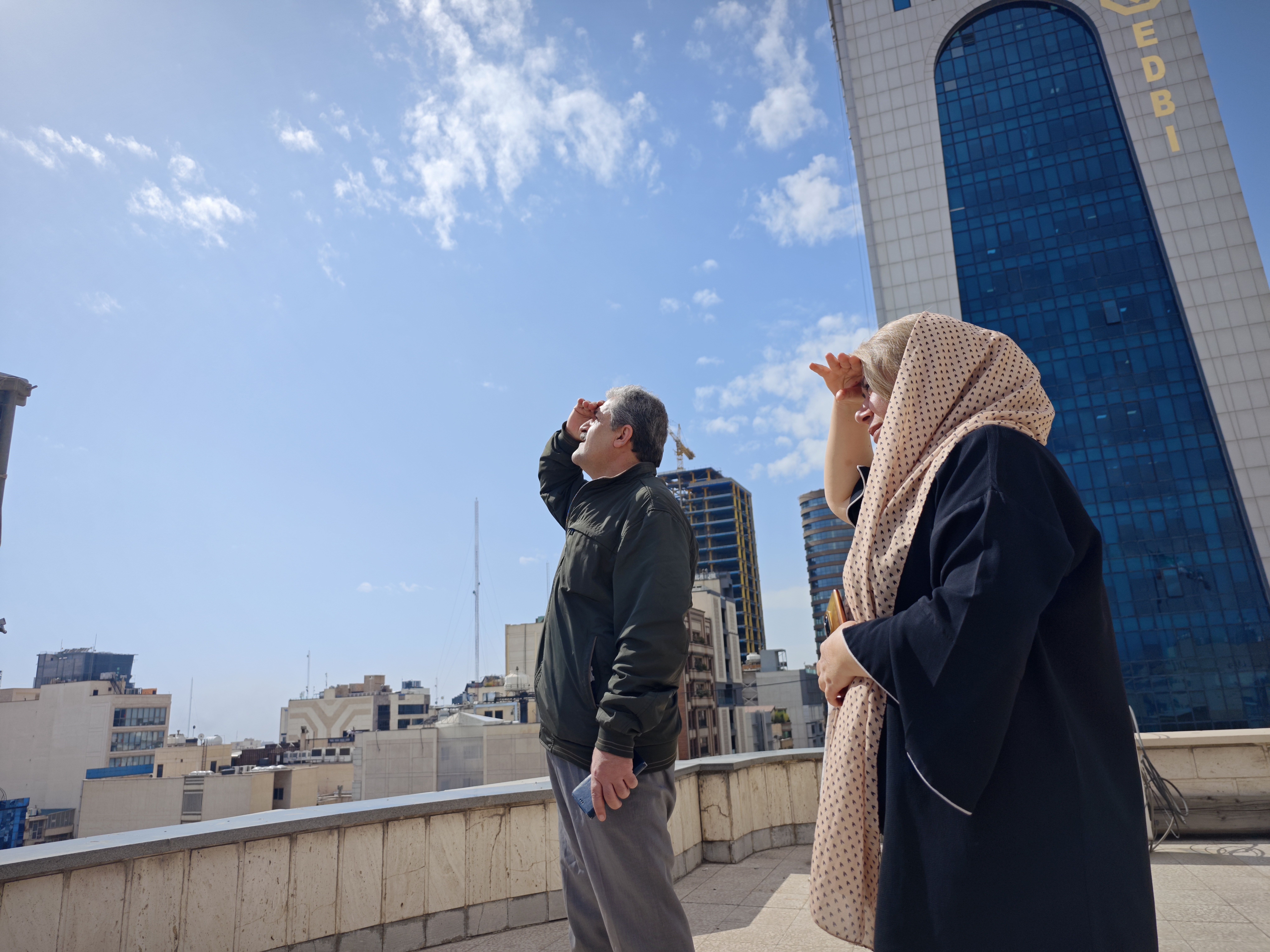TEHRAN, IRAN - FEBRUARY 28: People look the skies from a rooftop amid reports of widespread attacks in the country by the United States and Israel on February 28, 2026 in Tehran, Iran. After explosions were seen in the Iranian capital, the office of the Israeli Defense Minister issued a statement saying it had launched a preemptive strike against the country, followed by a statement from the U.S. president that they had launched combat operations. (Photo by Majid Saeedi/Getty Images)