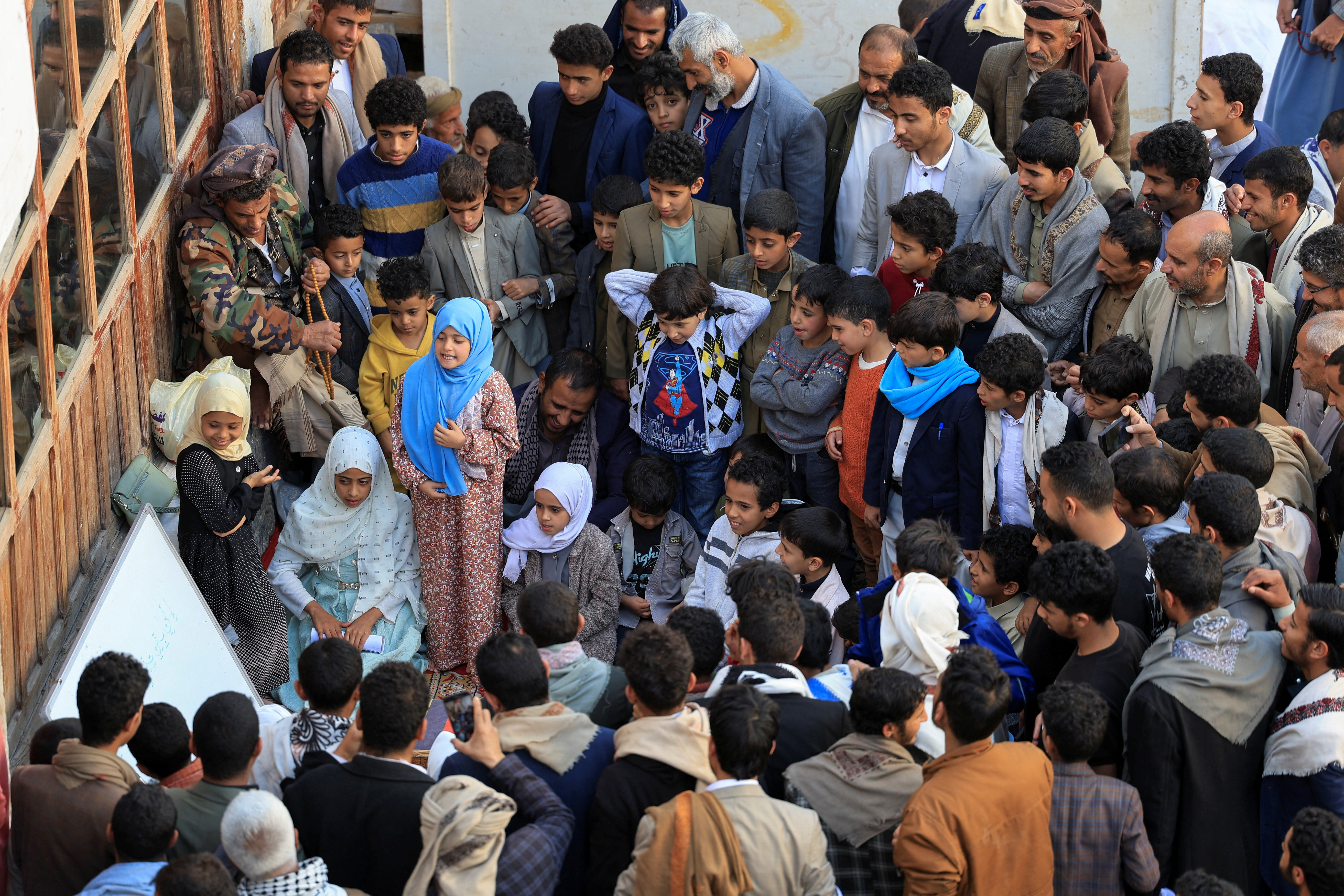 People gather around girls learning to recite the Holy Quran, ahead of the Muslim fasting month of Ramadan, at the Grand Mosque in Sanaa, Yemen February 3, 2026. REUTERS/Khaled Abdullah