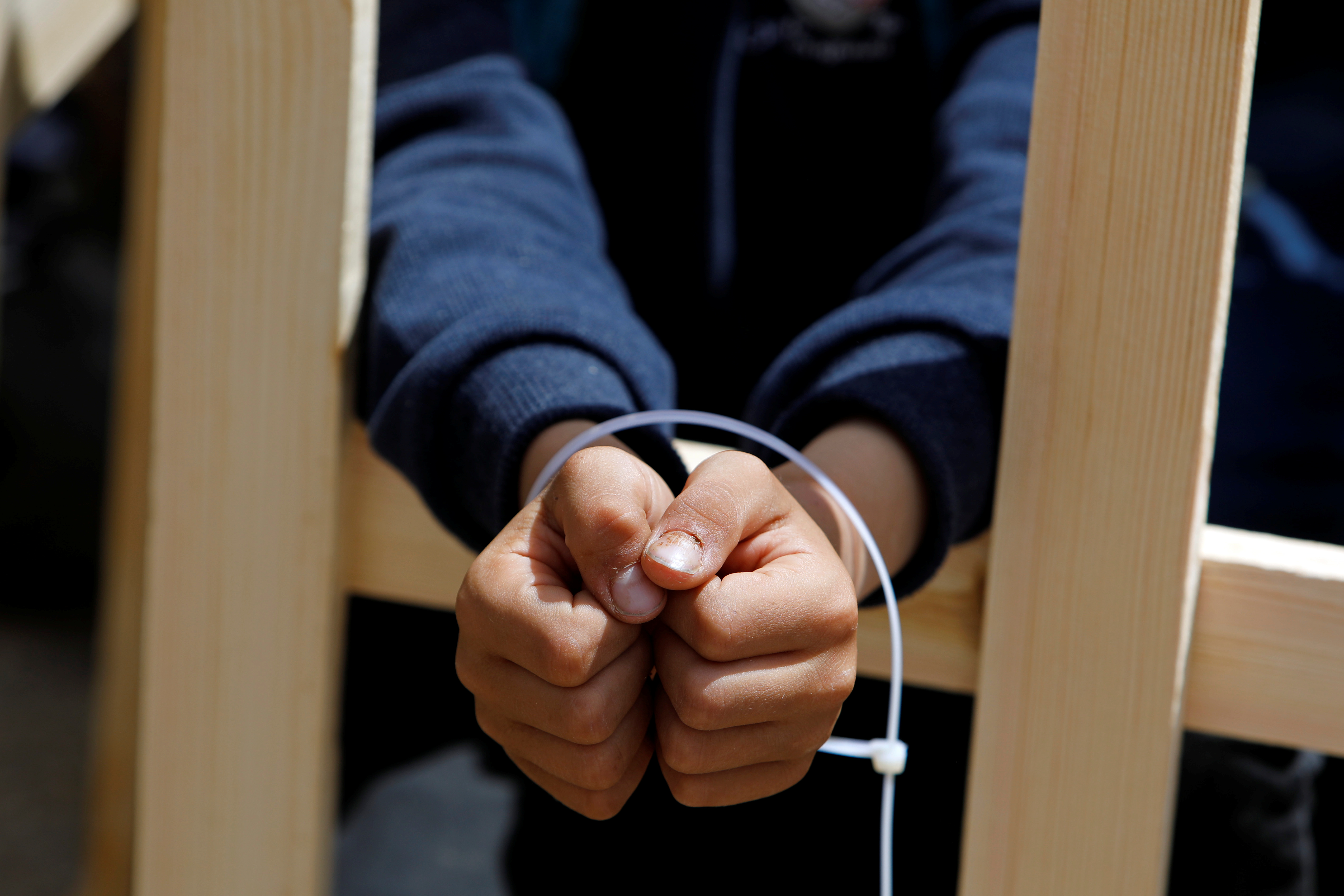 A boy with his hands tied during a rally to demand the release of Palestinian prisoners in the West Bank