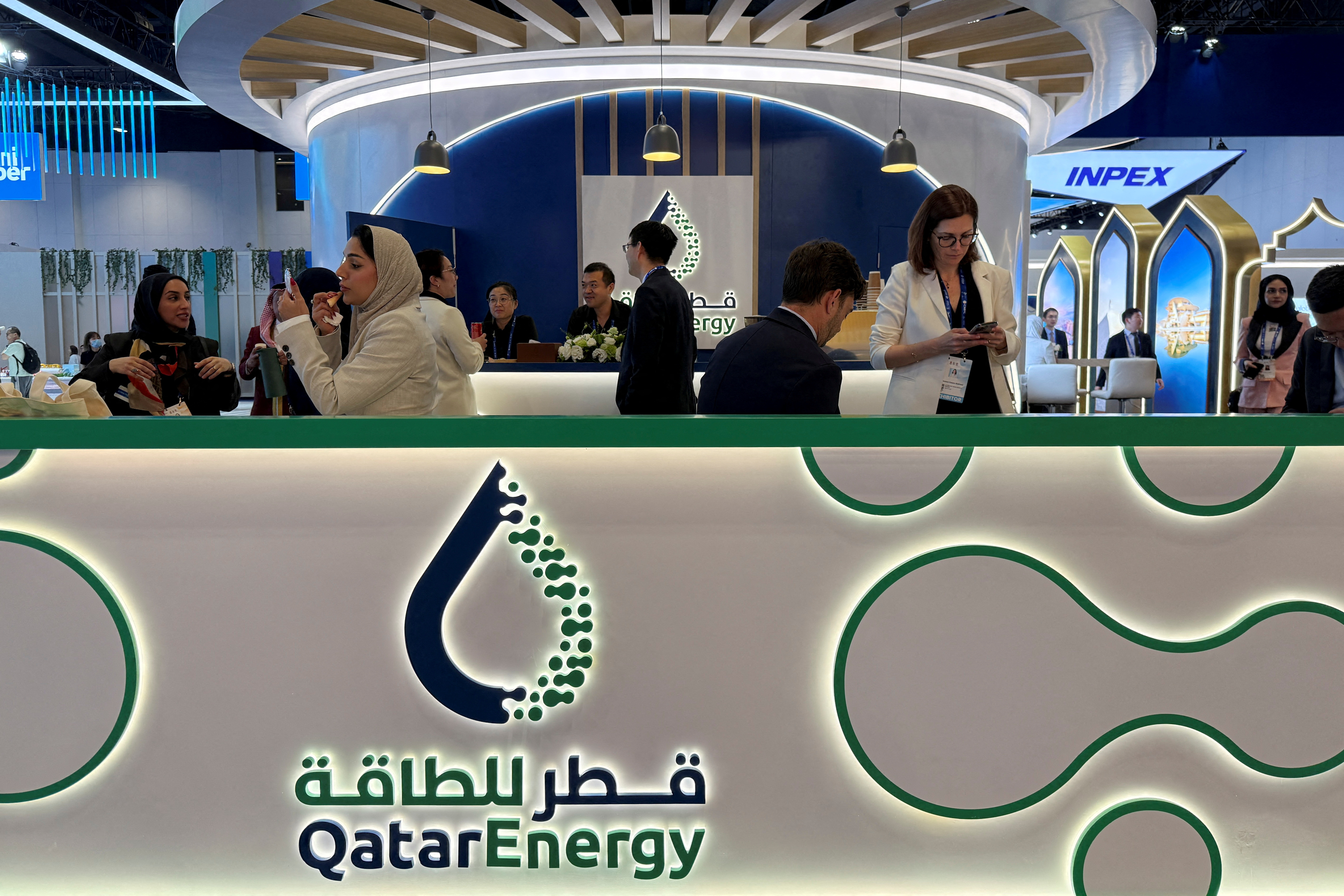 FILE PHOTO: People visit the QatarEnergy booth at the World Gas Conference exhibition in Beijing, China May 21, 2025. REUTERS/Liz Lee/File Photo