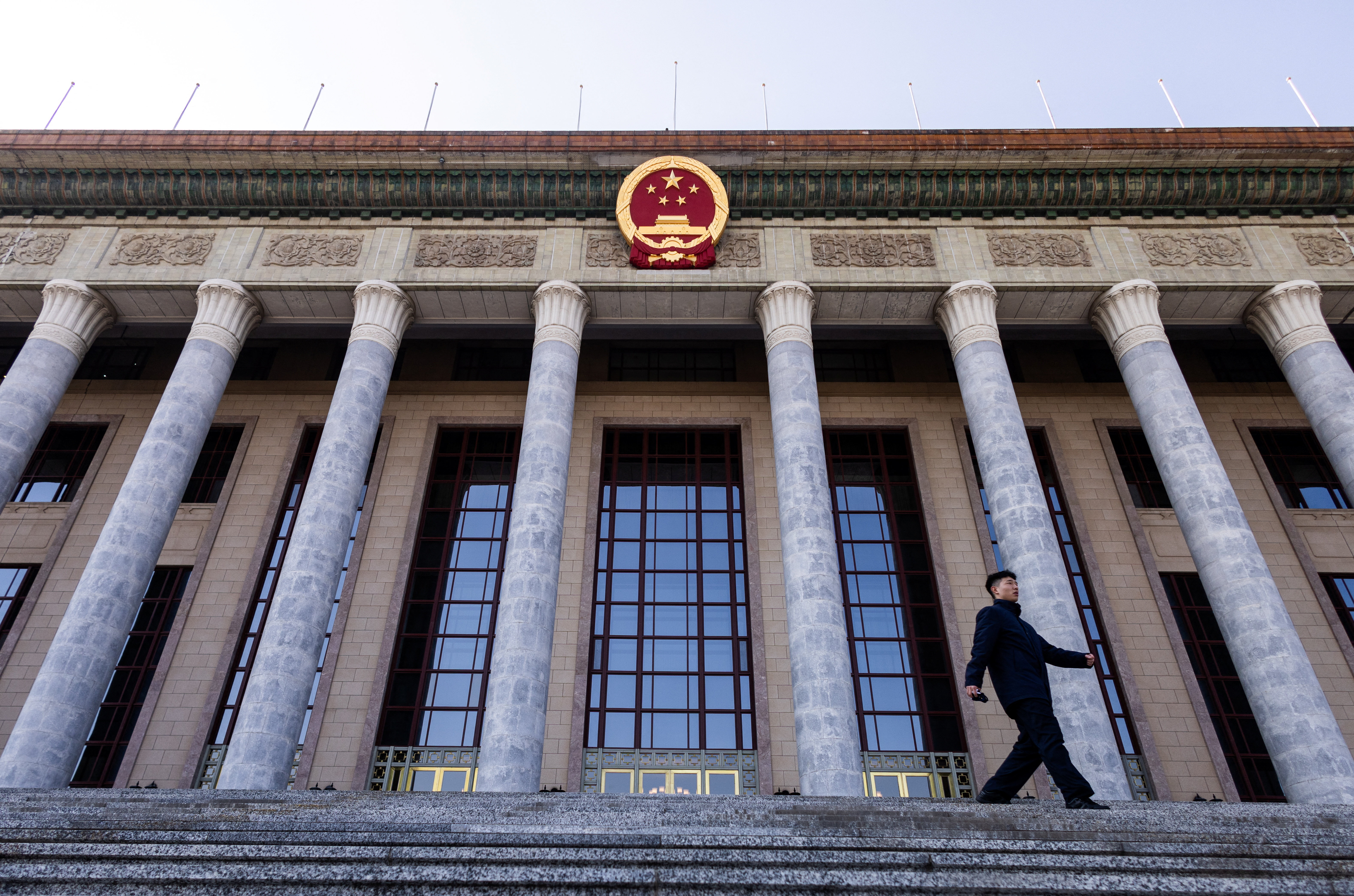 A man walks down the stairs at the entrance of the Great Hall of the People ahead of the annual meeting of the National People's Congress, in Beijing