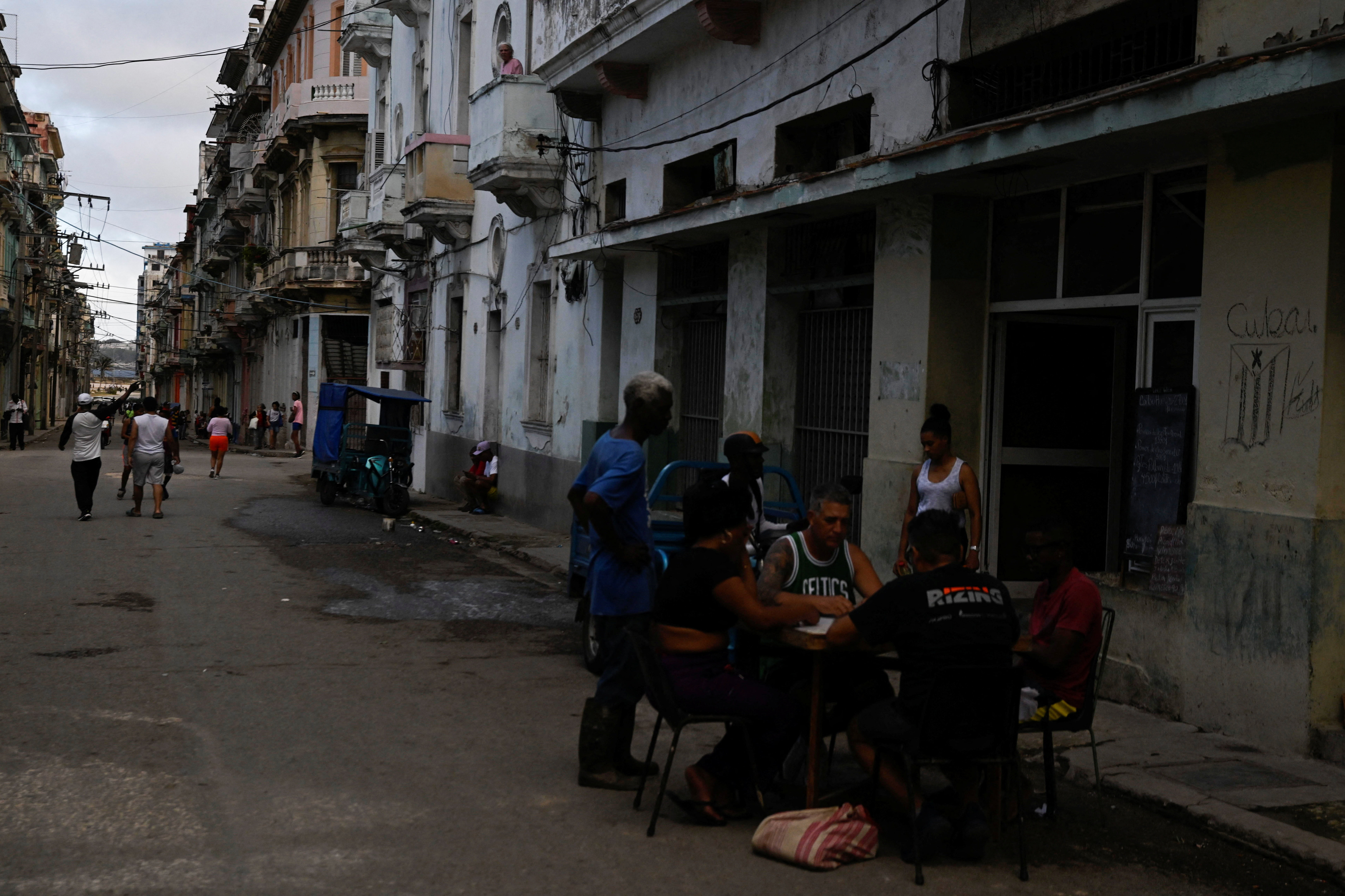 People play dominoes on the street during a mass blackout across most of the country, in Havana, Cuba March 4, 2026. REUTERS/Norlys Perez