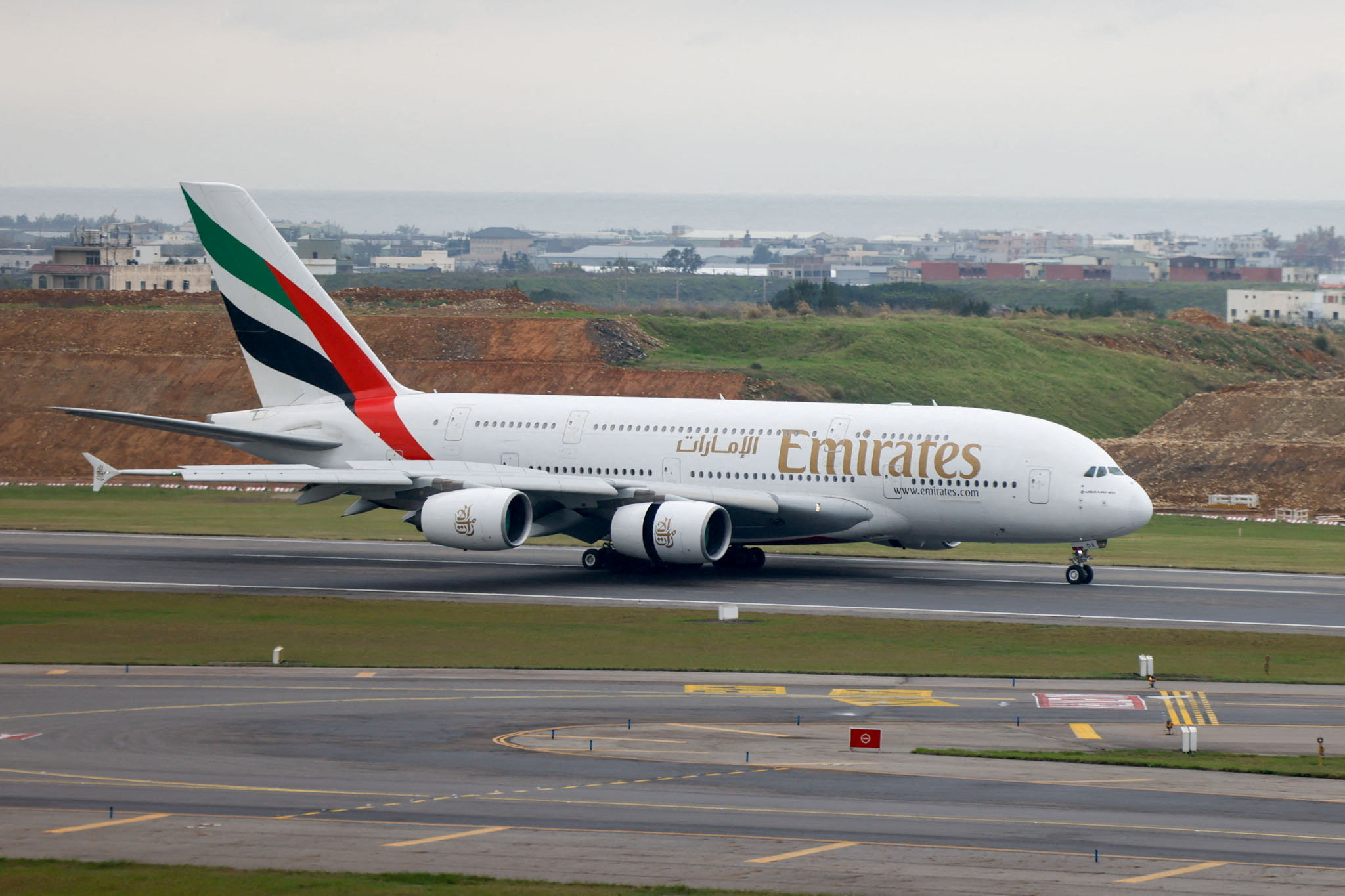 An Emirates plane lands in an airport.