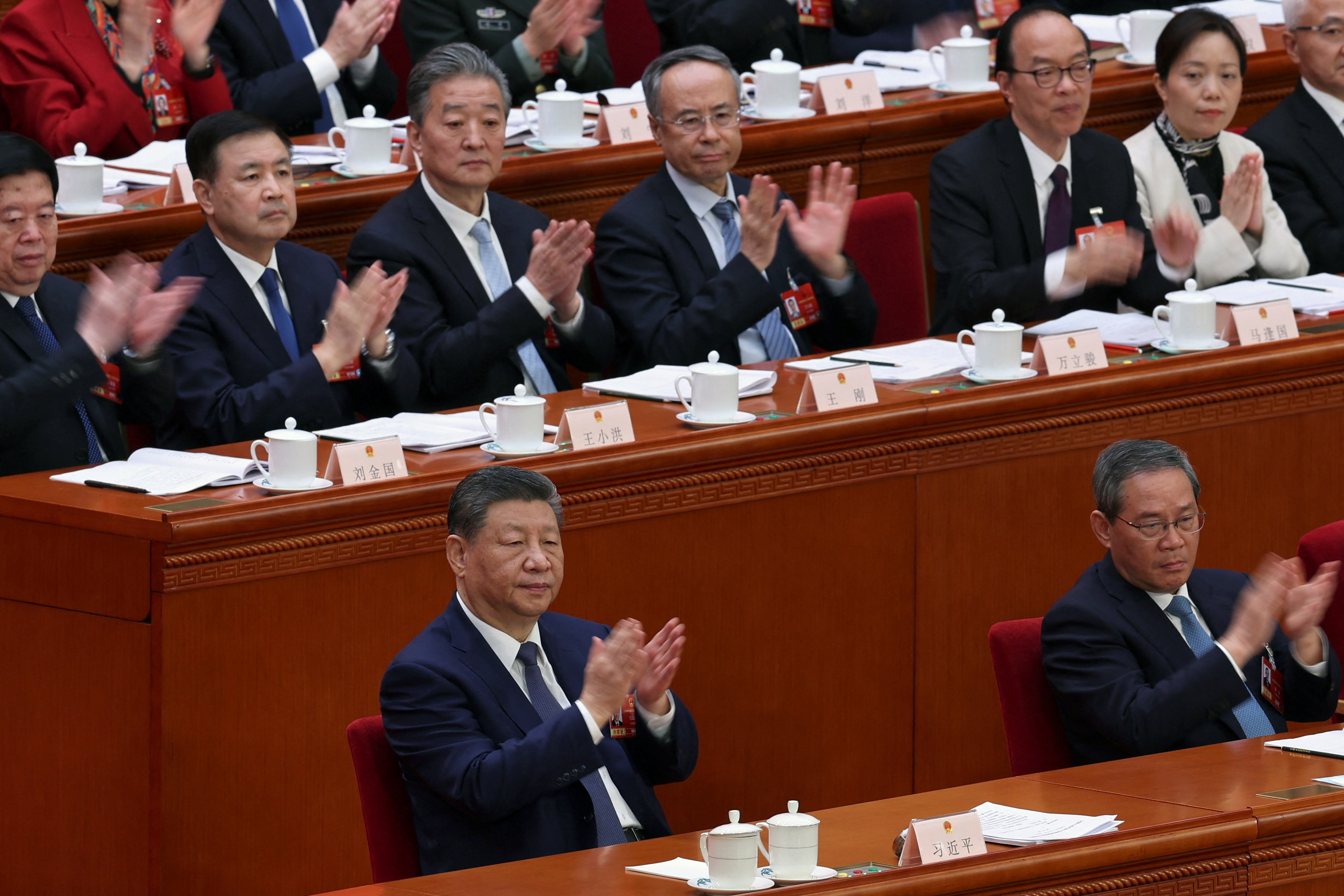 Chinese President Xi Jinping and Premier Li Qiang applaud at the second plenary session of the National People's Congress (NPC) at the Great Hall of the People in Beijing, China March 9, 2026. REUTERS/Florence Lo