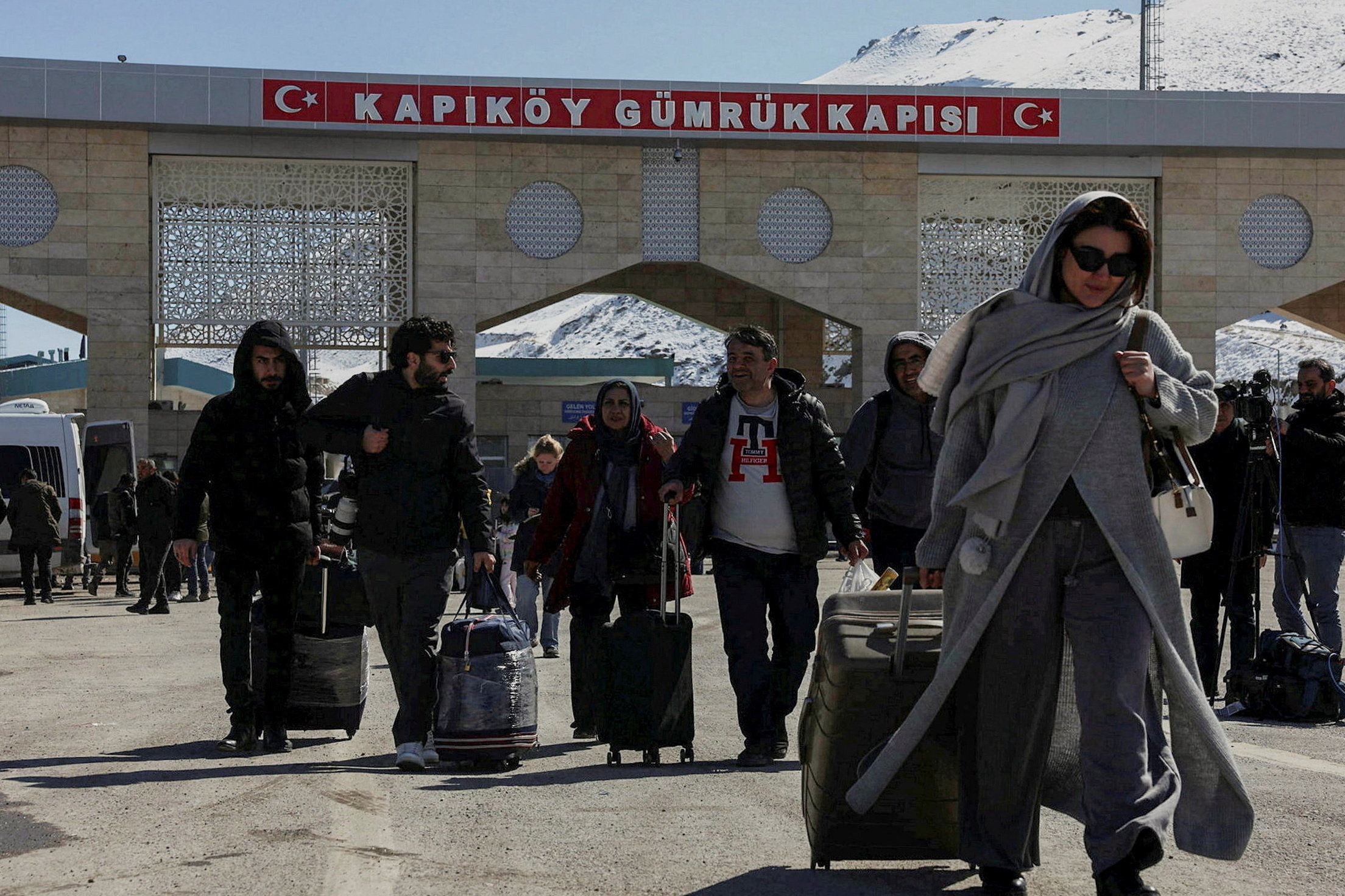 Iranians make their way after crossing into Turkiye at the Kapikoy border in the eastern Van province