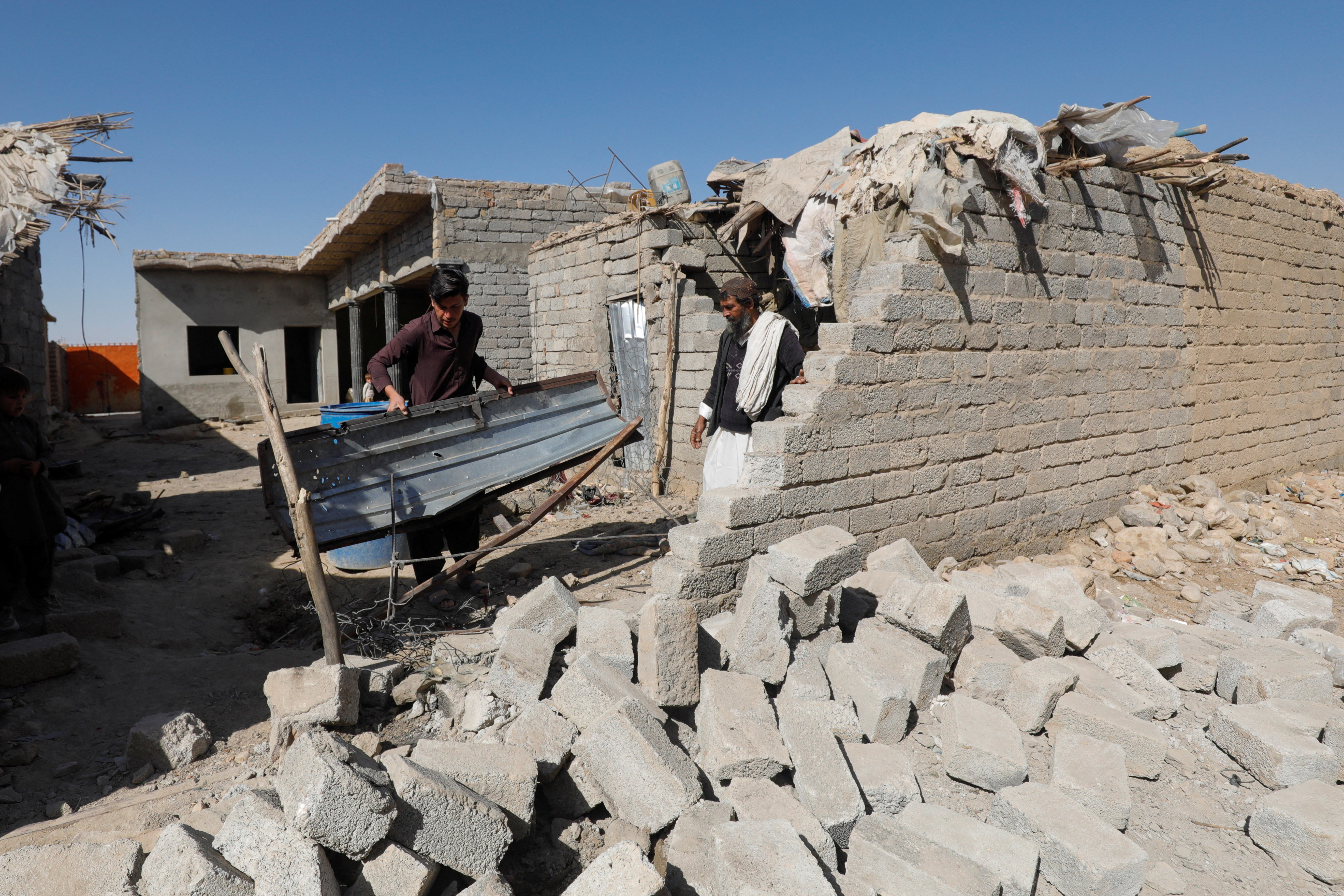 Residents inspect the damage after what locals say was a possible drone that hit a residential house in the provincial capital of Quetta, Pakistan