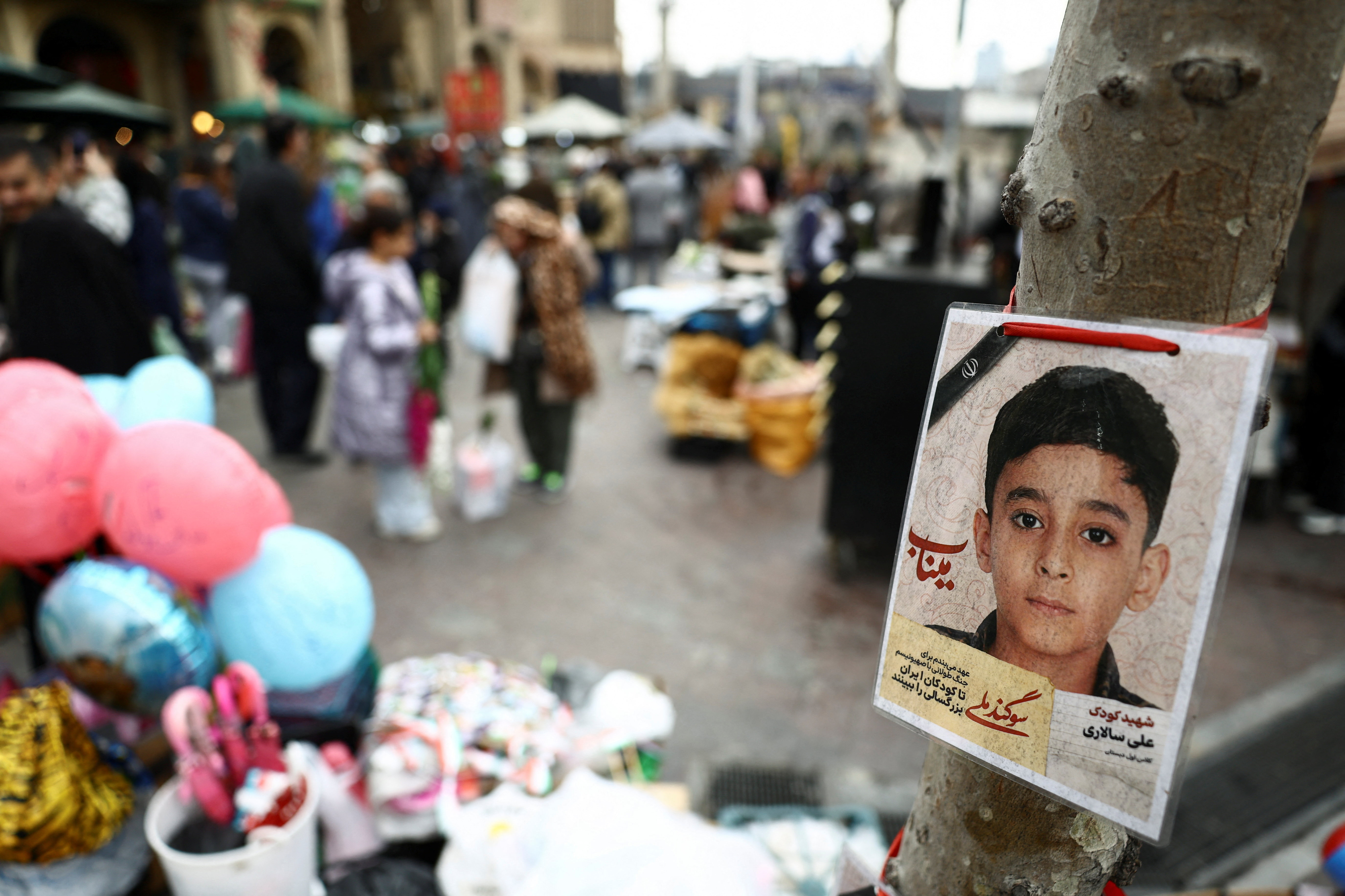 A picture of a child victim killed in a strike is displayed at Tajrish Bazaar, in Tehran