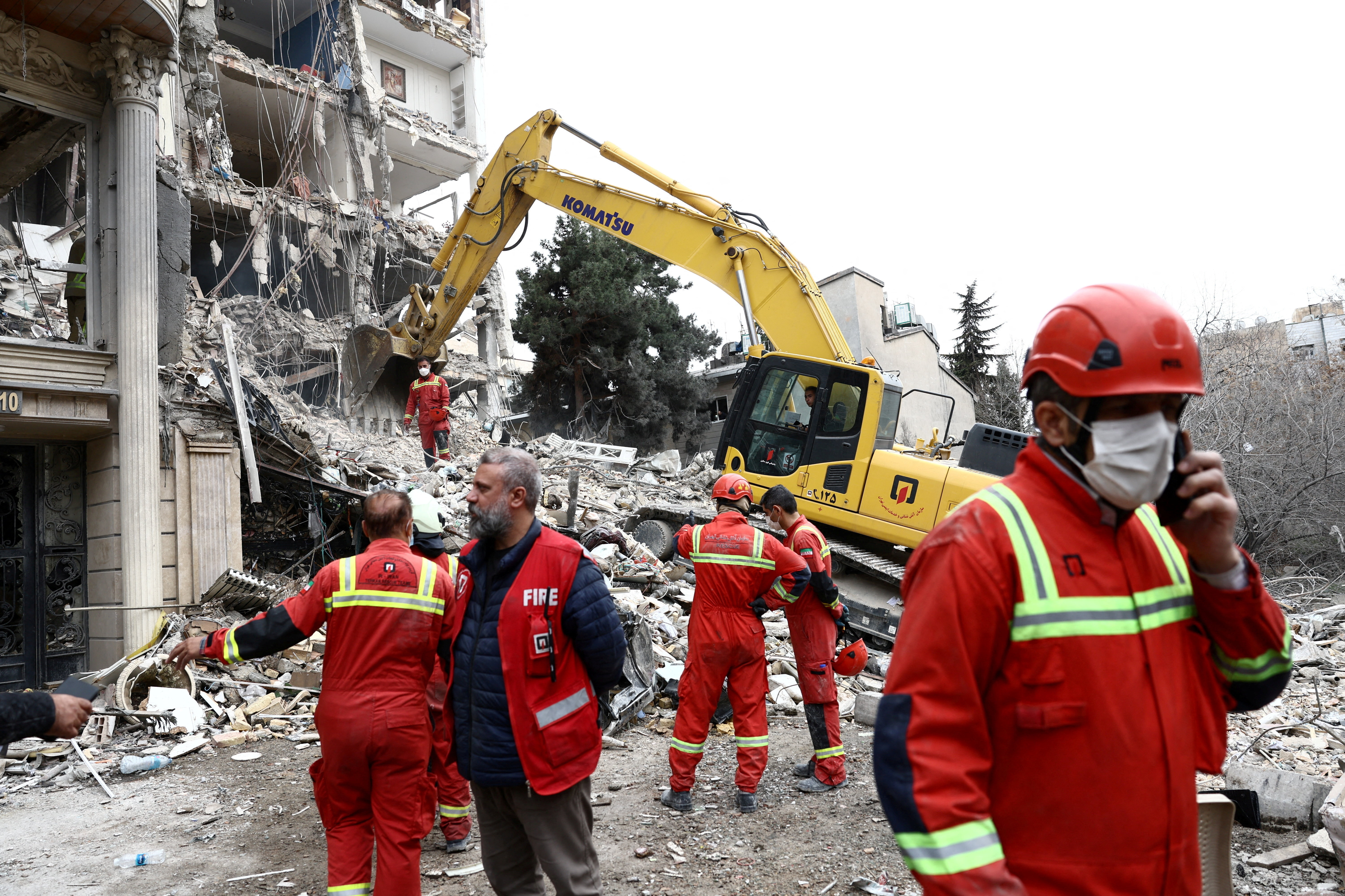 Emergency personnel work at the site of a strike on a residential building.