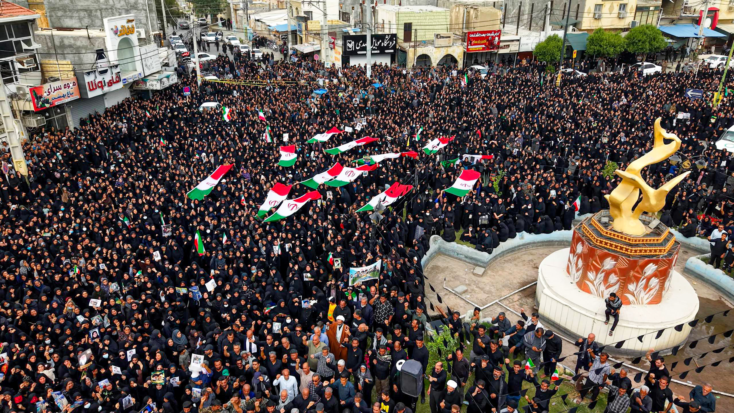 Mourners carry Iranian flags and portraits as they gather during a funeral ceremony for children, who lost their lives after a primary school in Iran’s Hormozgan province was targeted in US and Israeli attacks, on March 03, 2026 in Minab, Iran. Thousands of people, including families and officials, attended the ceremony.