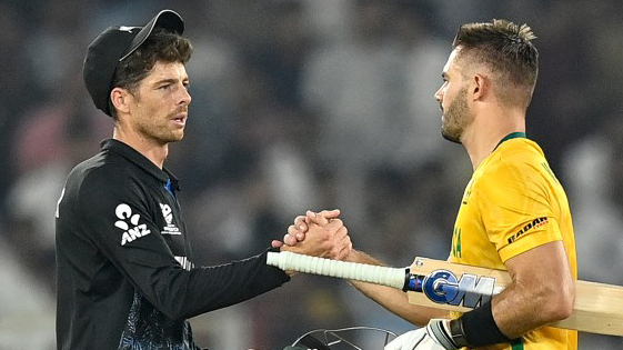 South Africa's captain Aiden Markram (R) is congratulated by his New Zealand counterpart Mitchell Santner.