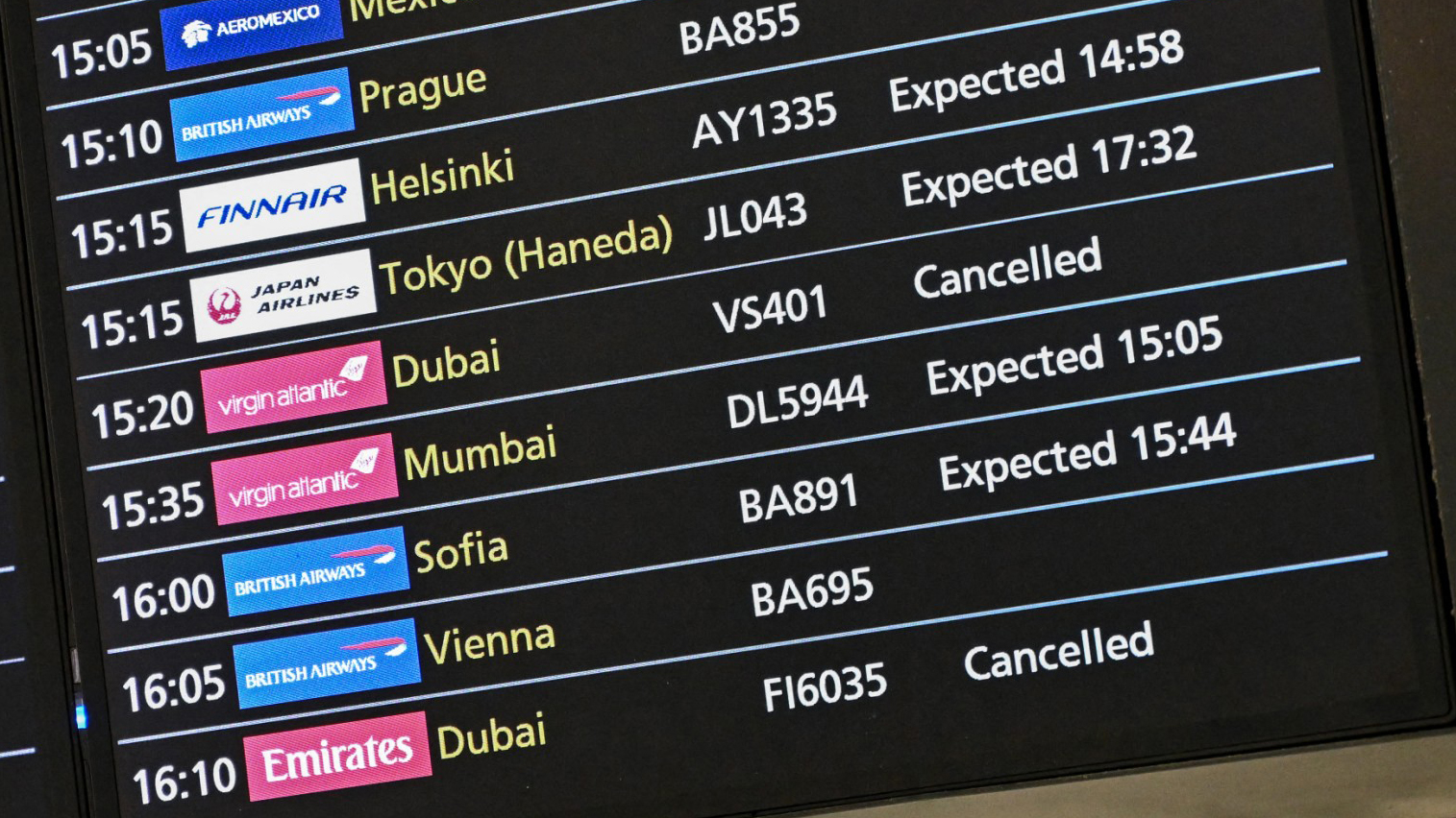 This general view shows the Terminal 3 arrivals board, with flights from Dubai cancelled, at London Heathrow Airport