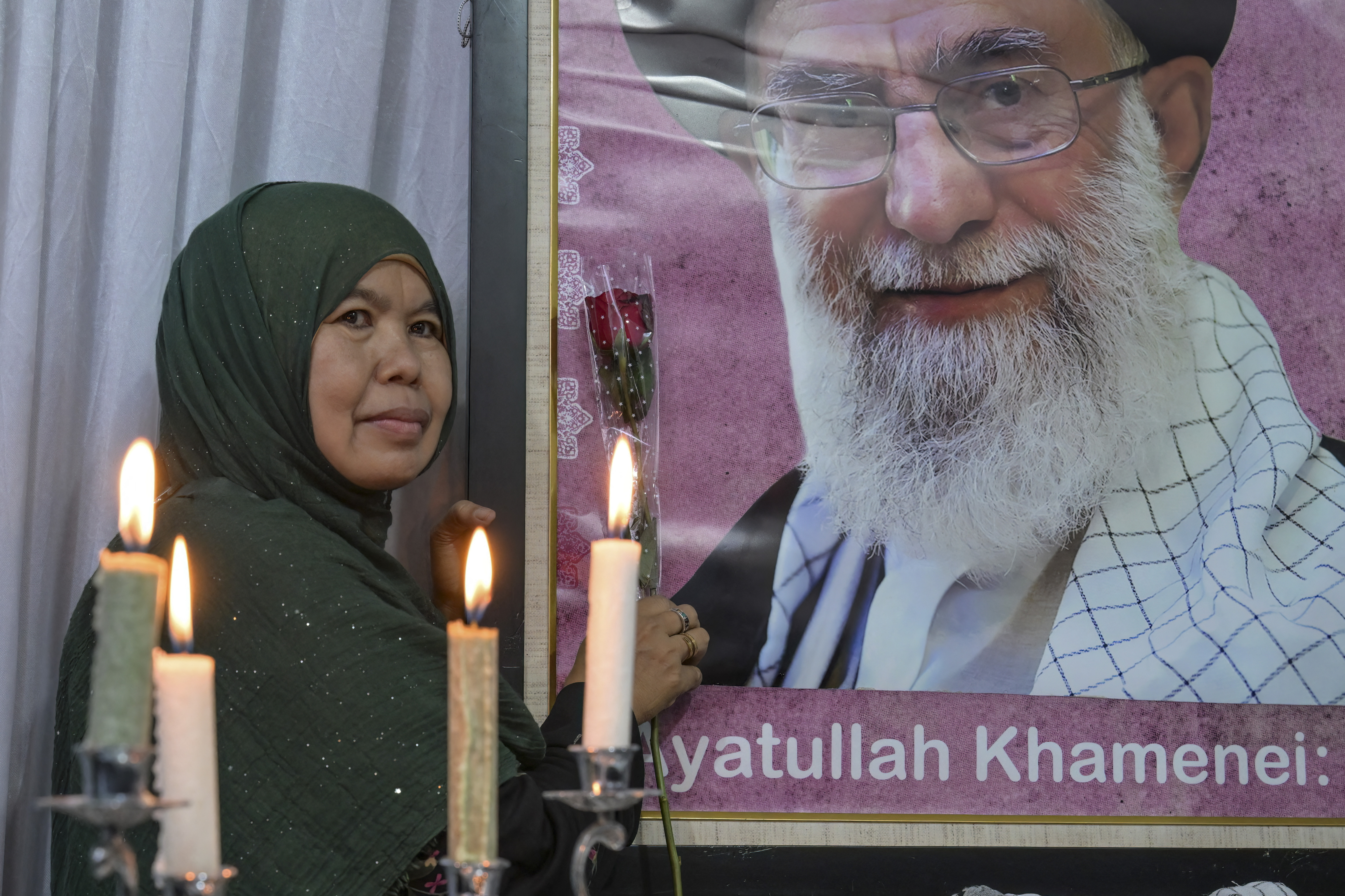 A mourner poses next to a portrait of Iranian supreme leader Ayatollah Ali Khamenei, who was killed amid US-Israel strikes, during the signing of a petition committing to international justice values, held at the Iranian Ambassador's residence in Jakarta on March 5, 2026. (Photo by BAY ISMOYO / AFP)