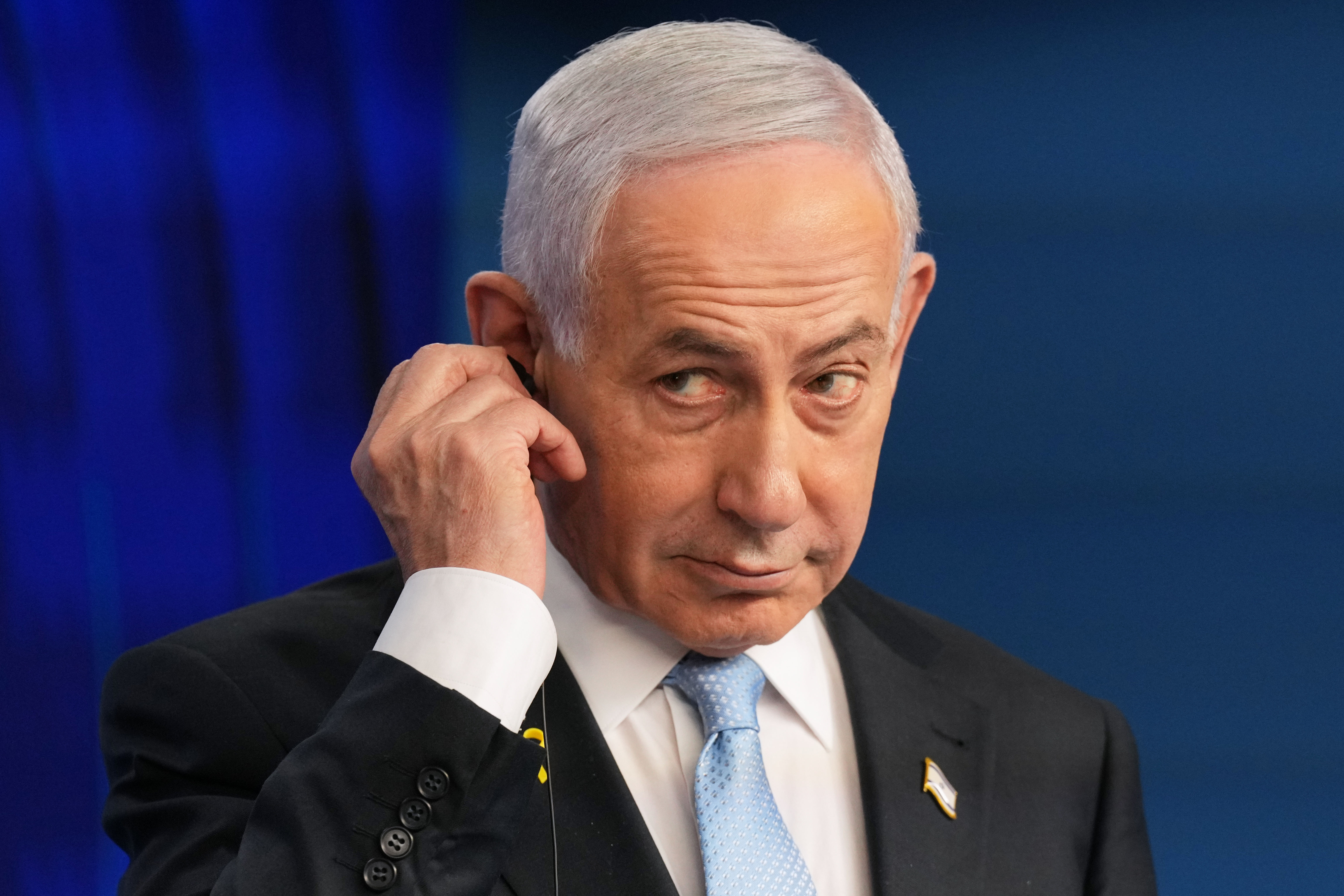 FILE - Israeli Prime Minister Benjamin Netanyahu adjusts the headphones during a joint press conference with German Chancellor Friedrich Merz in Jerusalem Sunday, Dec. 7, 2025. (AP Photo/Ariel Schalit, Pool, File)