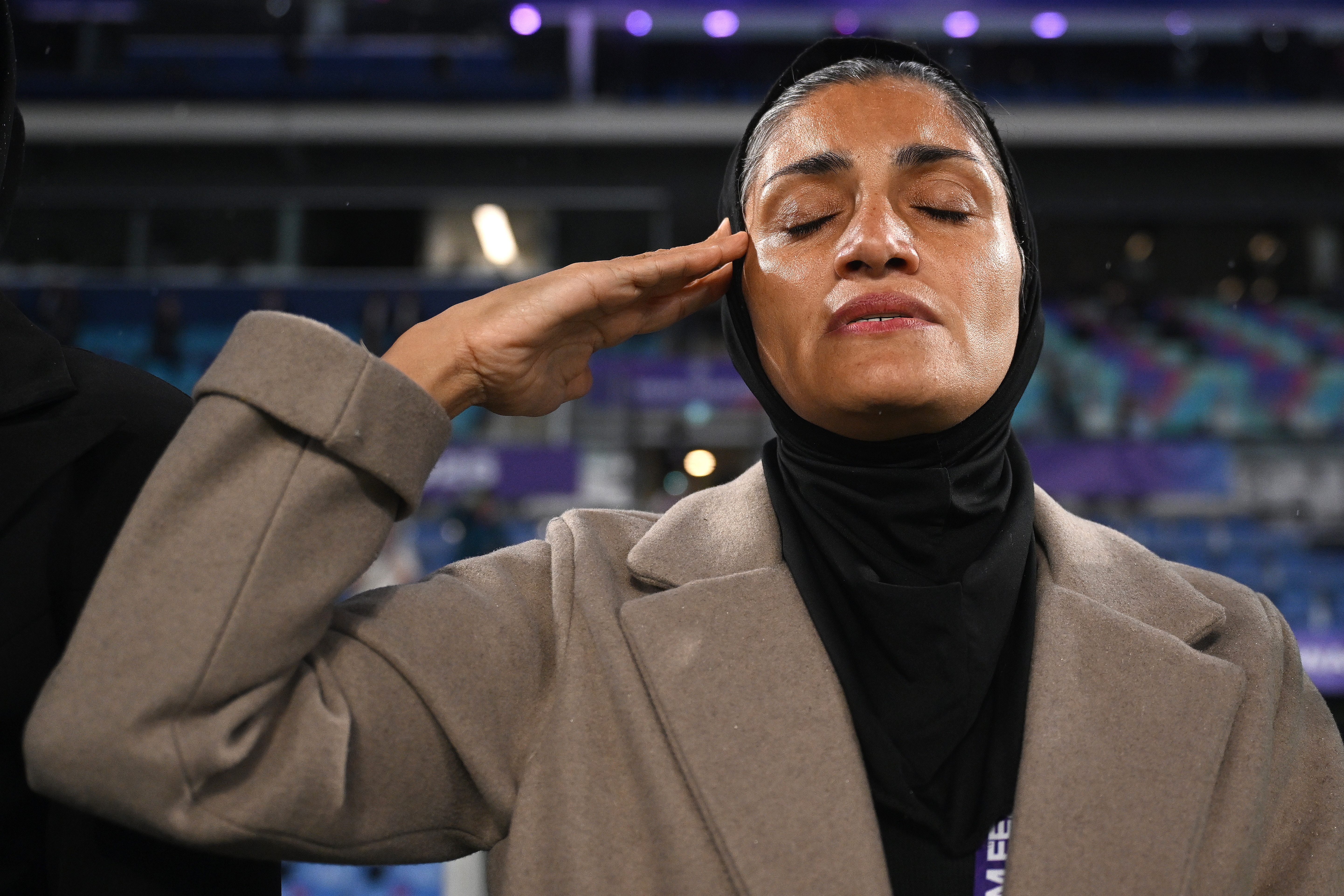 Iran coach Marziyeh Jafari salutes during the national anthem ahead of the Women's Asian Cup soccer match between Iran and the Philippines in Robina, Australia, Sunday, March 8, 2026. (Dave Hunt/AAP Image via AP)