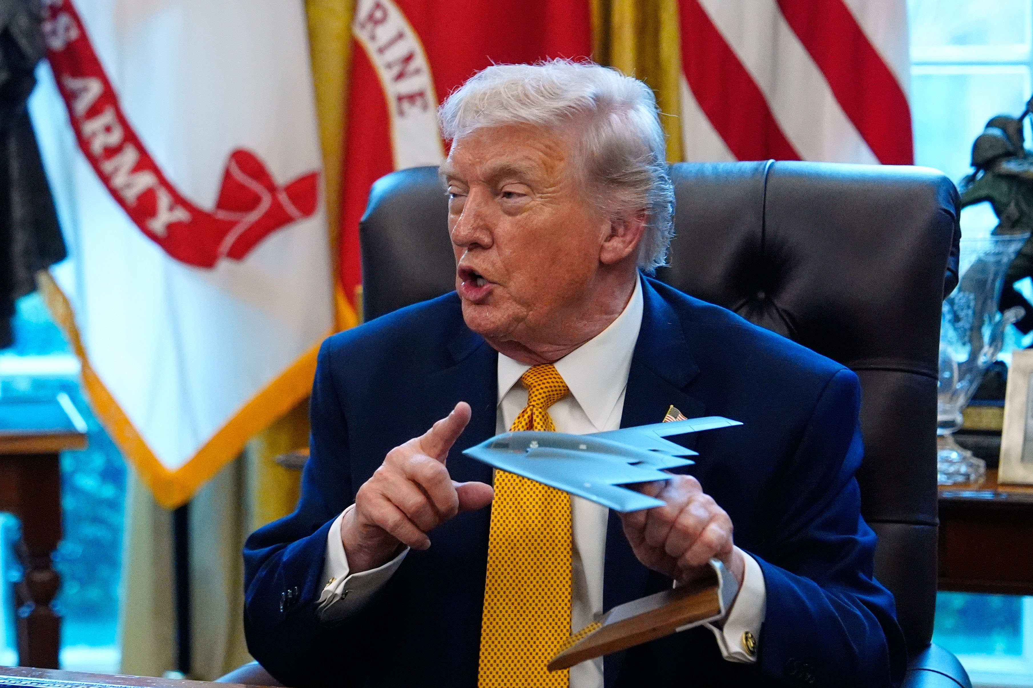 President Donald Trump holds a model of a B-2 stealth bomber as he speaks after signing an executive order regarding a task force on fraud in the Oval Office of the White House, Monday, March 16, 2026, in Washington. [Julia Demaree Nikhinson/AP Photo]