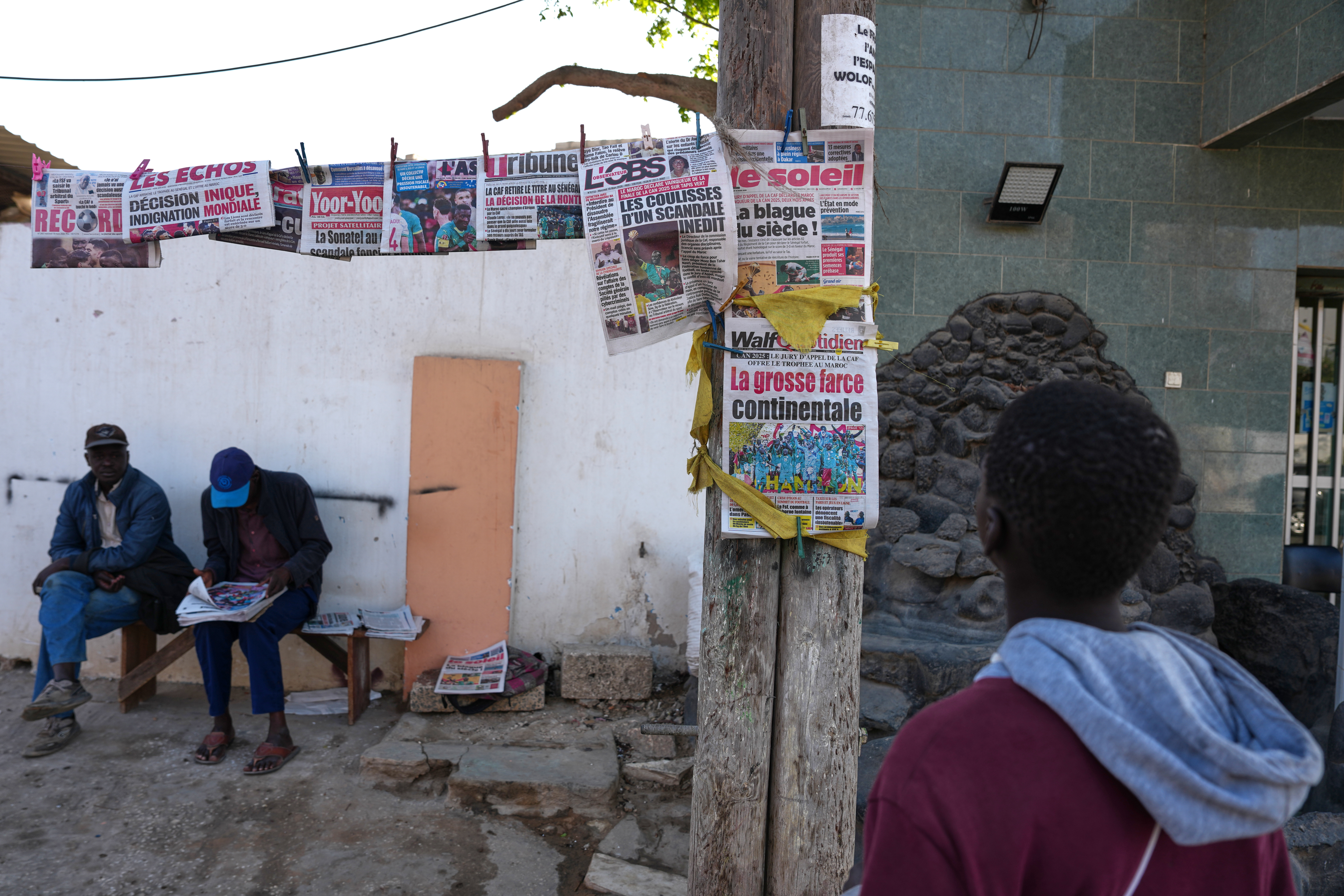 People read newspapers reporting on the Confederation of African Football decision stripping the Senegal national football team of their Africa Cup of Nations title and awarding it to Morocco national football team in Dakar, Senegal