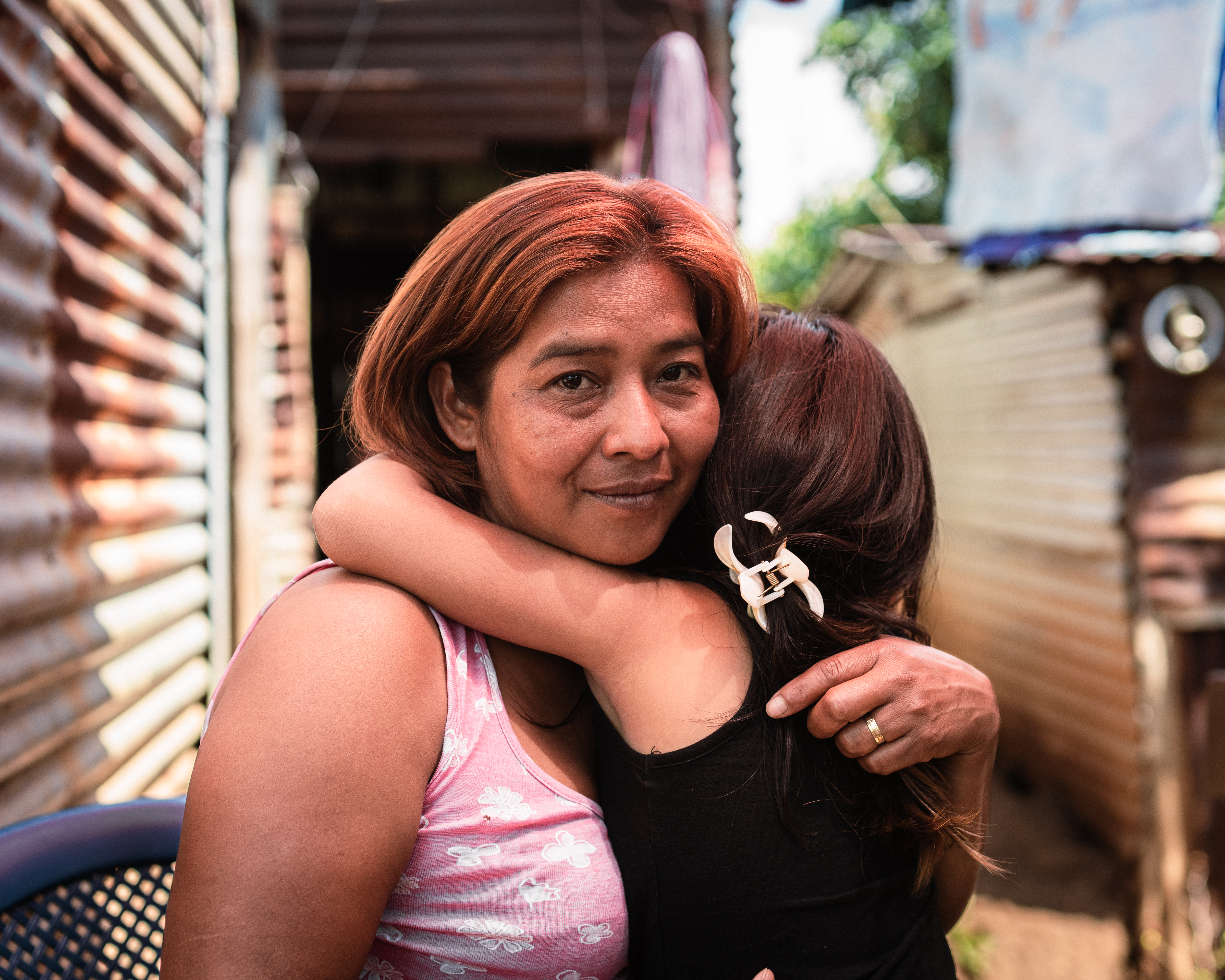 Rubidia Hernández and her 6-year-old granddaughter pictured in their home, where her son also used to live, in the outskirts of Nahuizalco, El Salvador. [Euan Wallace/ Al Jazeera]