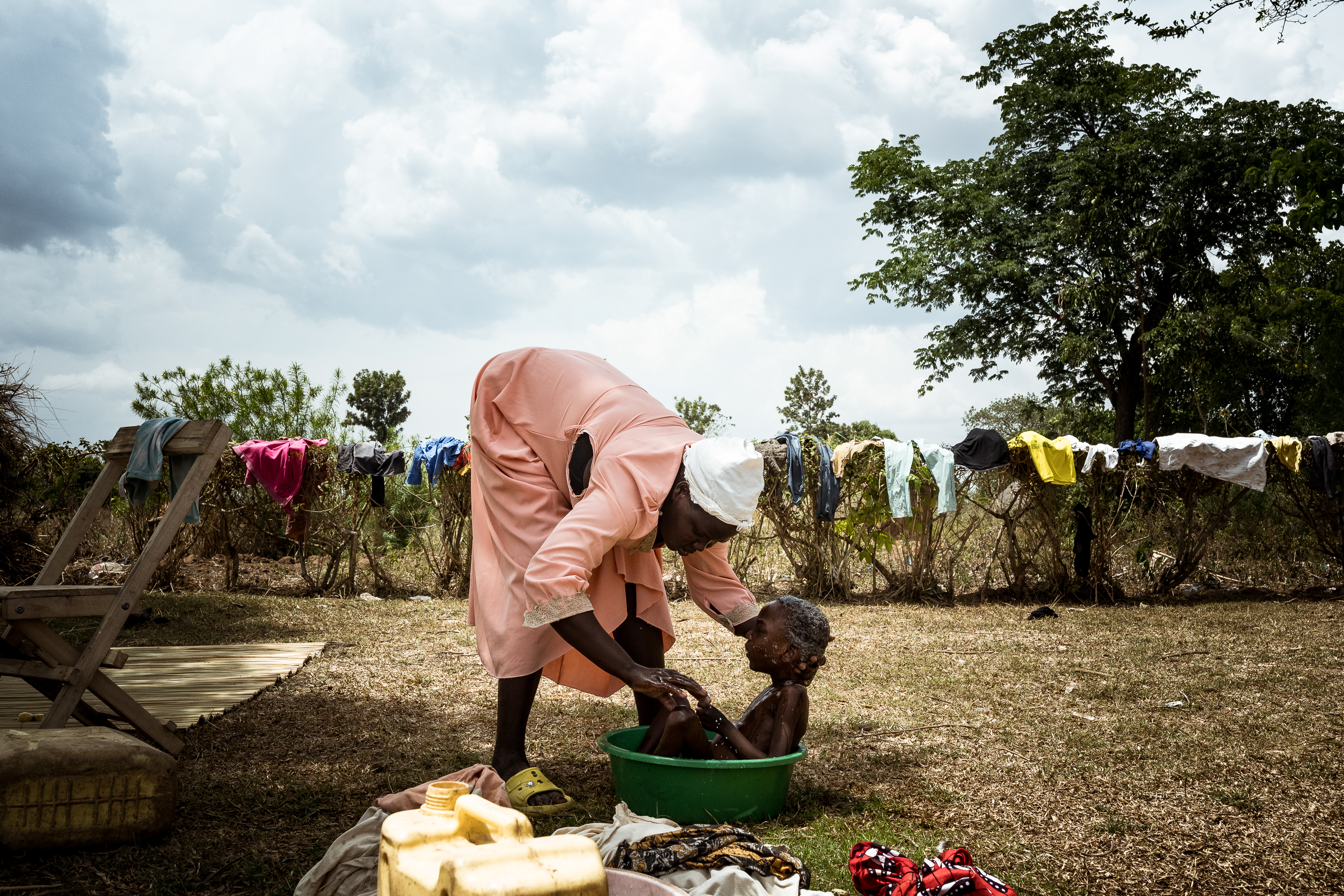 9th February 2026. Owalai, Uganda. Martha Apolot, 21 bathes her son Aaron Elayu, 8. Aaron lives with an undiagnosed disability and is cared for solely by his young mother Martha after she fell pregnant in dubious circumstances at age 13. She has been shunned by her family and recieves little assistance from them. Aaron needs up to four baths a day as he cannot clean himself after he defecates. Photograph by Christopher Hopkins