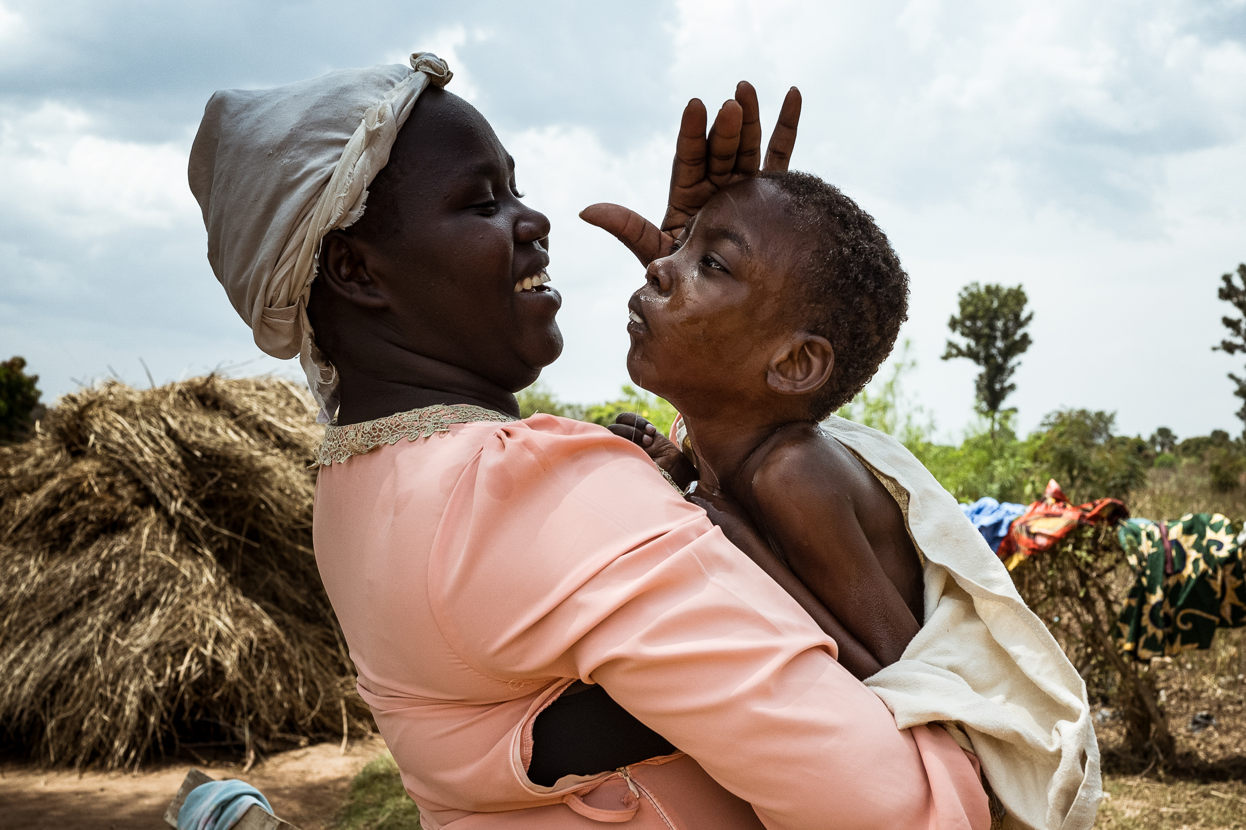 9th February 2026. Owalai, Uganda. Martha Apolot, 21 dries her son Aaron Elayu, 8 after she bathed him. Aaron lives with an undiagnosed disability and is cared for solely by his young mother Martha after she fell pregnant in dubious circumstances at age 13. She has been shunned by her family and recieves little assistance from them. Aaron needs up to four baths a day as he cannot clean himself after he defecates. Photograph by Christopher Hopkins
