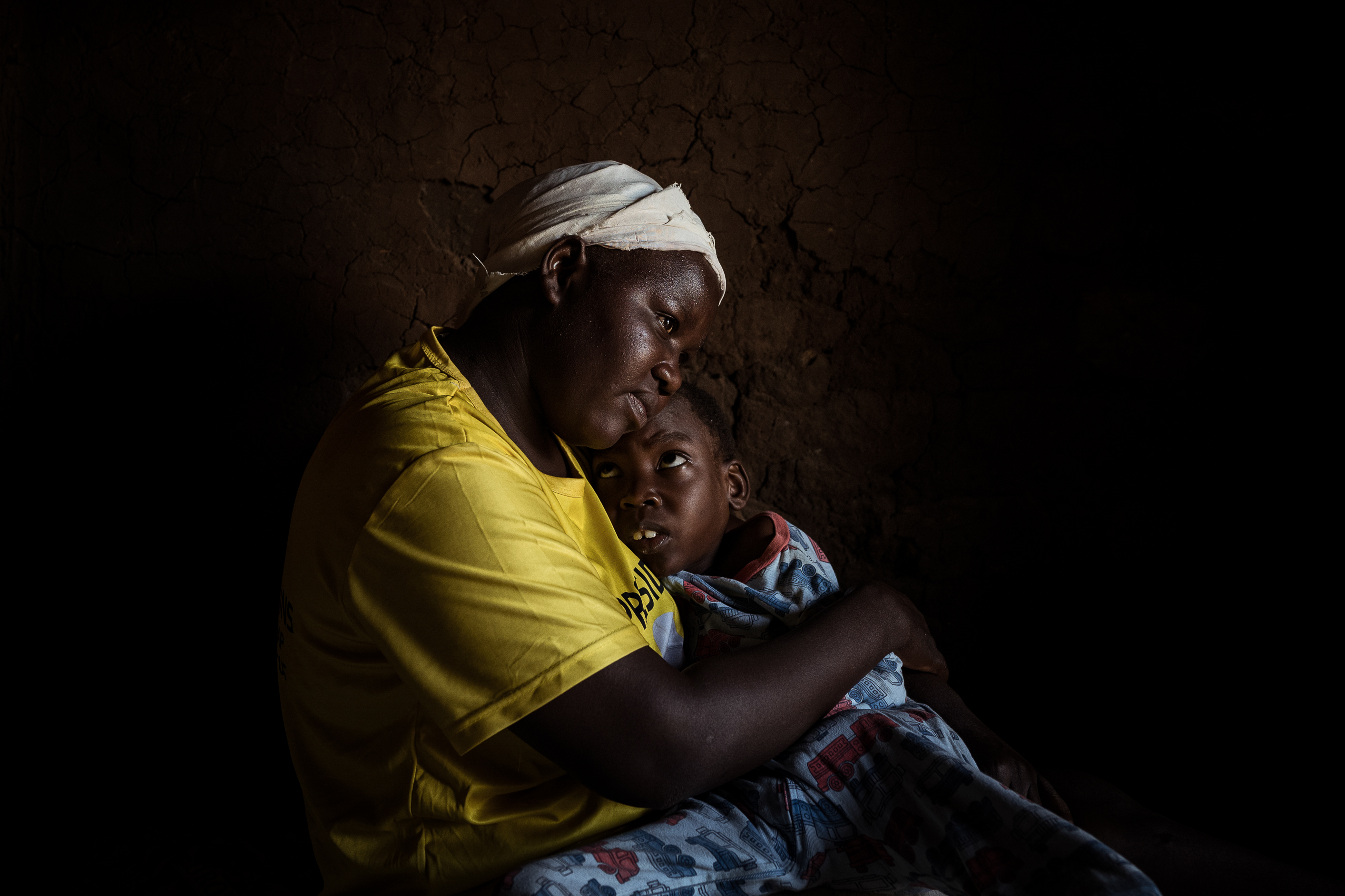 10th February 2026. Owalai, Uganda. Martha Apolot, 21 embraces her son Aaron Elayu, 8. Aaron lives with an undiagnosed disability and is cared for solely by his young mother Martha after she fell preganant in dubious circumstances at age 13. Photograph by Christopher Hopkins