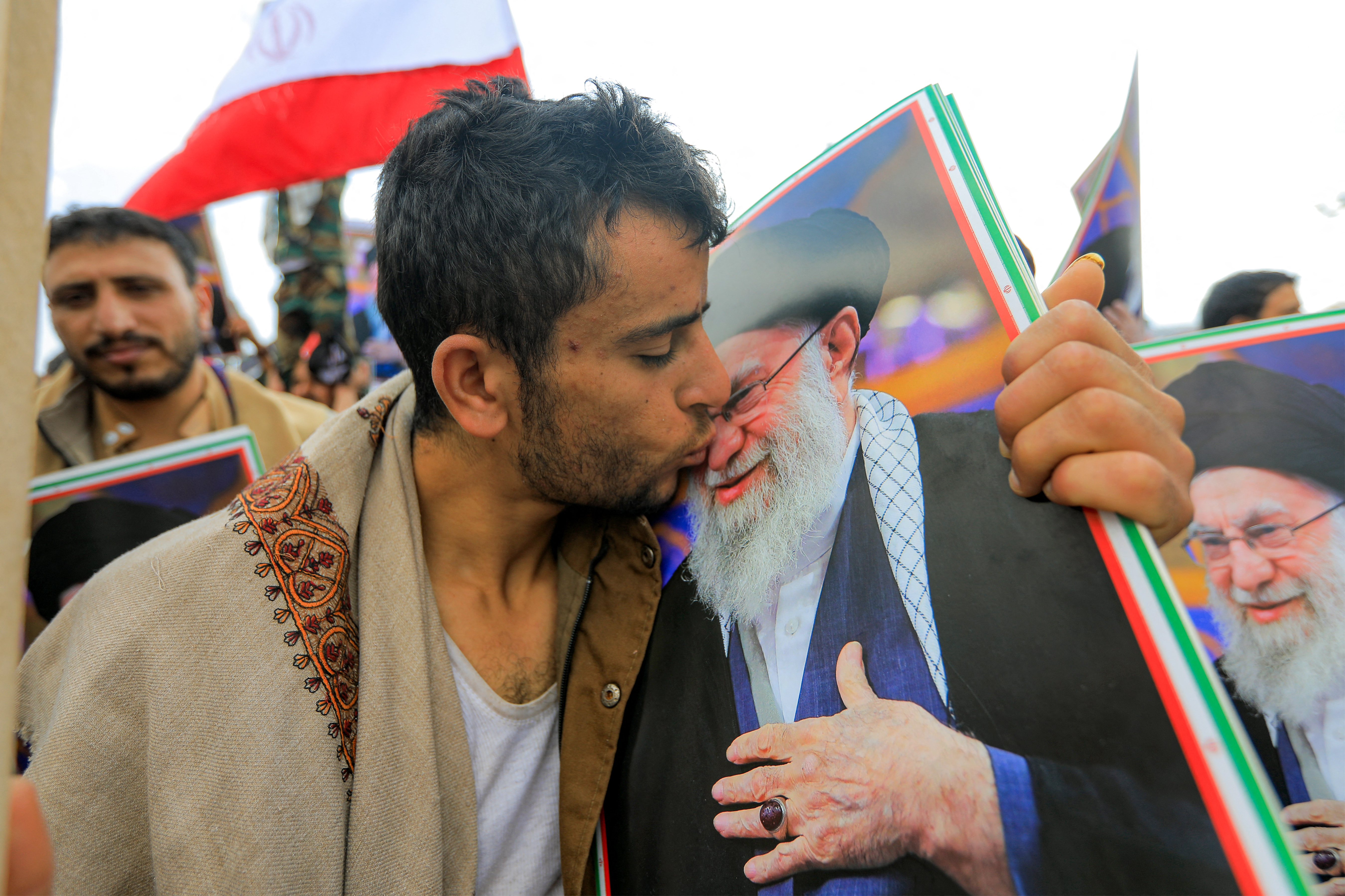 TOPSHOT - A man kisses a picture of Iran's supreme leader Ali Khamenei during a memorial rally held by supporters of Yemen's Huthis, a day after Khamenei was assassinated during US and Israeli strikes on Tehran, in the Huthi-held capital Sanaa on March 1, 2026.