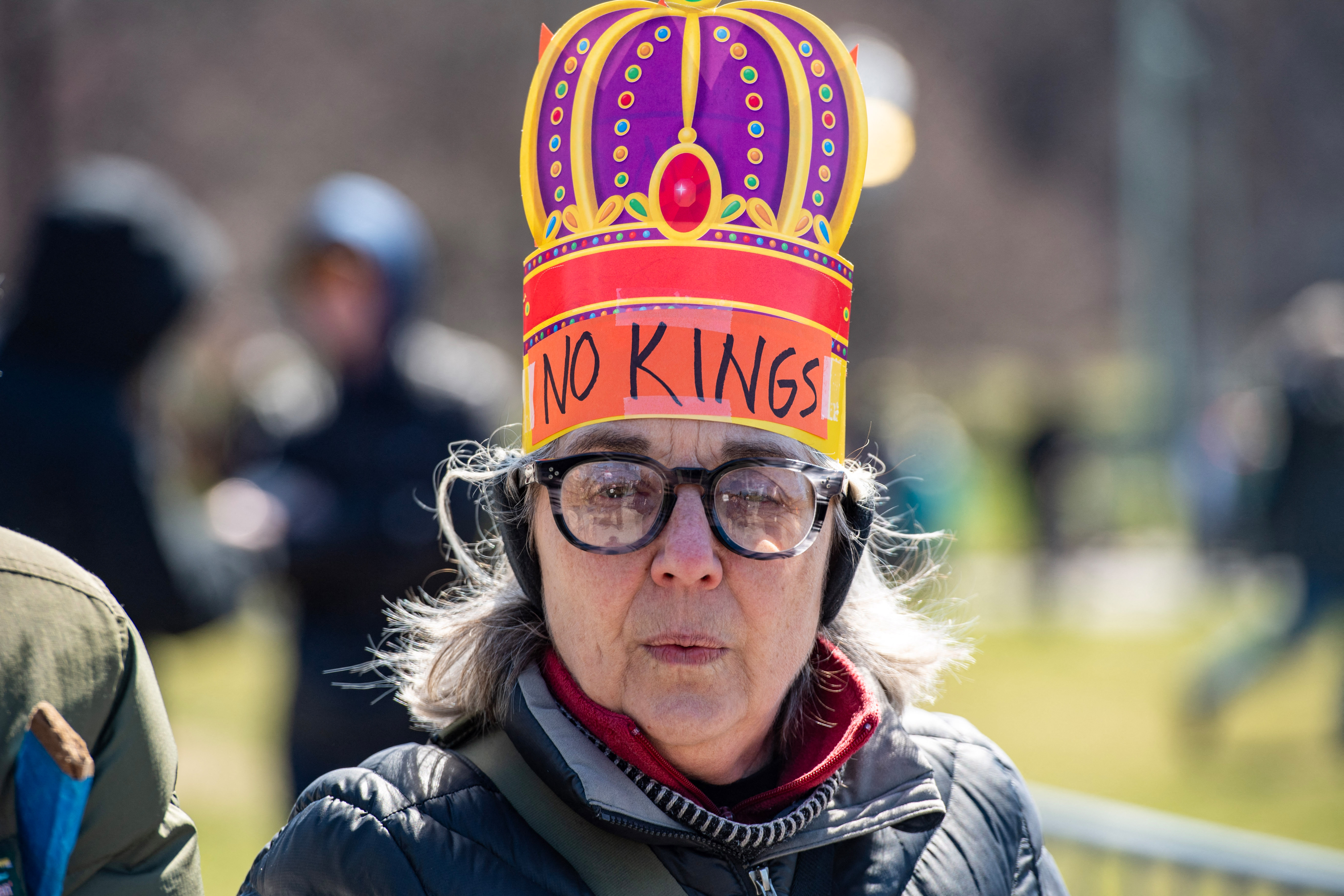A protester wearing a paper crown arrives for the "No Kings" national day of protest in Boston, Massachusetts, on March 28, 2026.
