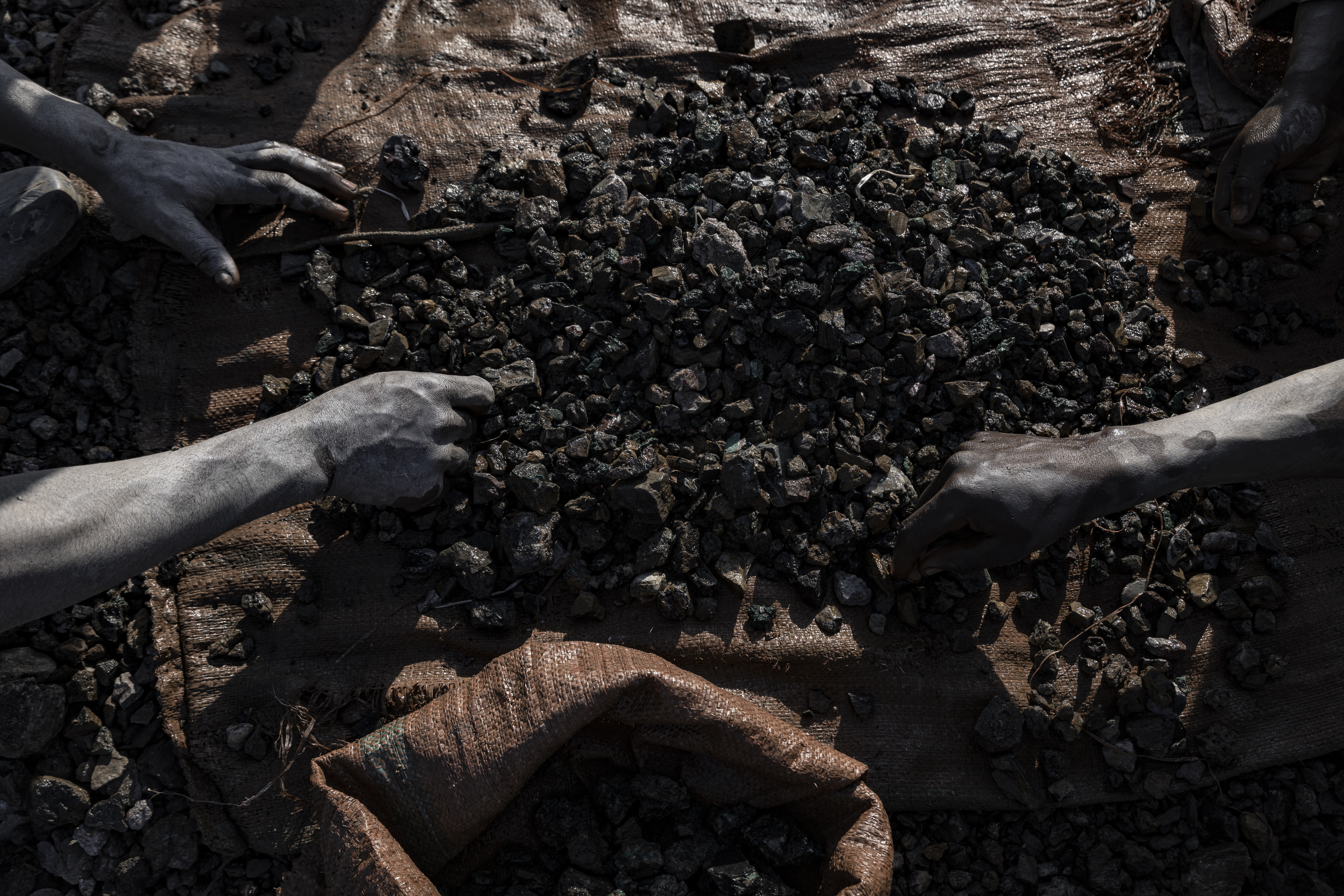 KOLWEZI, DEMOCRATIC REPUBLIC OF CONGO - MAY 26: People collect copper and cobalt stones on the ground at an artisanal mine site on May 26, 2025 in Kolwezi, Democratic Republic of Congo. (Photo by Michel Lunanga/Getty Images)