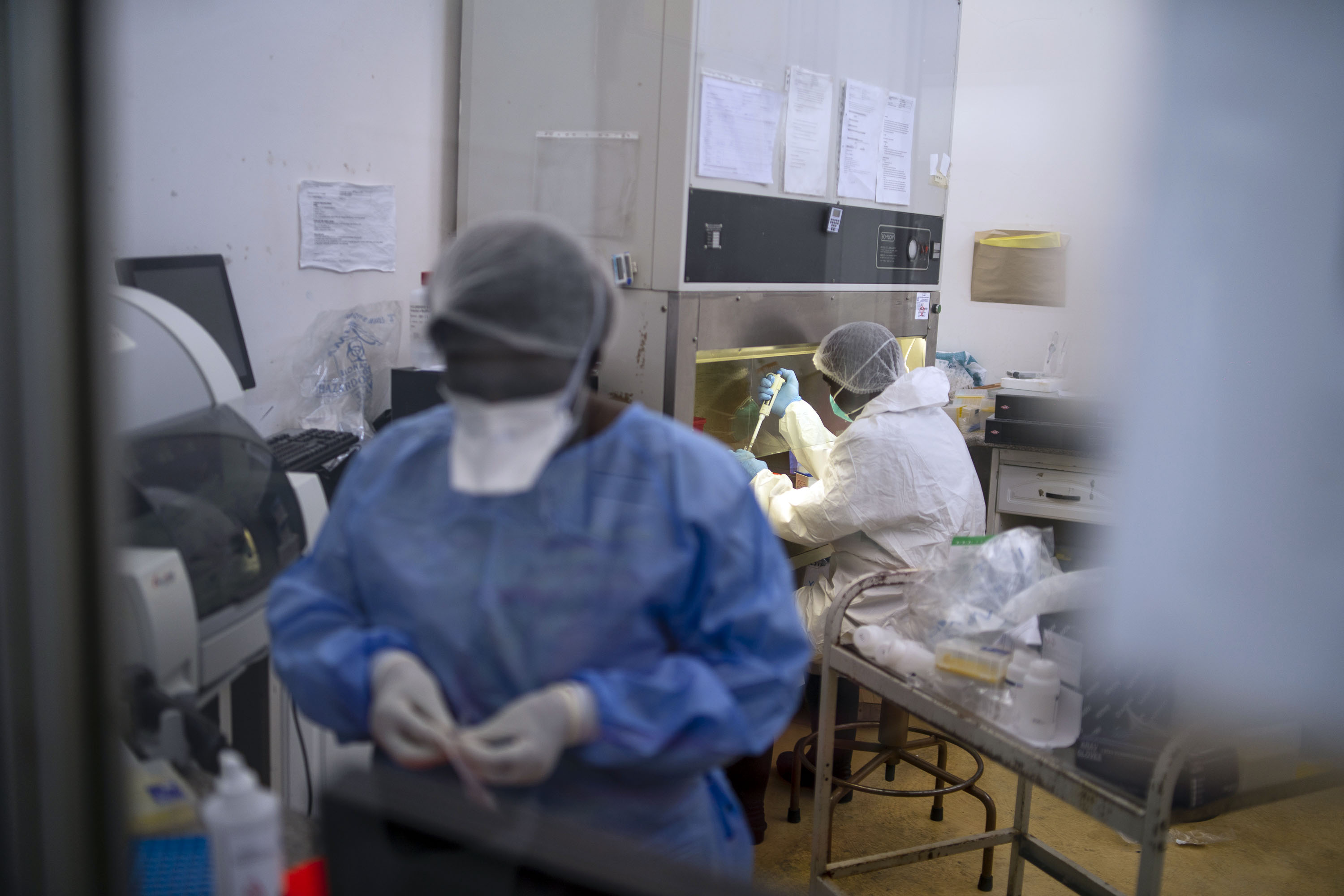 BULAWAYO, ZIMBABWE - JANUARY 28: Health workers extract Covid-19 specimens in the laboratory at Mpilo Central Hospital on January 28, 2021 in Bulawayo, Zimbabwe. Covid-19 related mortality rates have increased at Zimbabwe's second largest hospital and authorities have decided to test all 2,100 staff members and all patients currently admitted to the public hospital. The hospital is now recording an average of 10-12 deaths per day from all its wards, an increase from 3-7 deaths. (Photo by KB Mpofu/Getty Images)