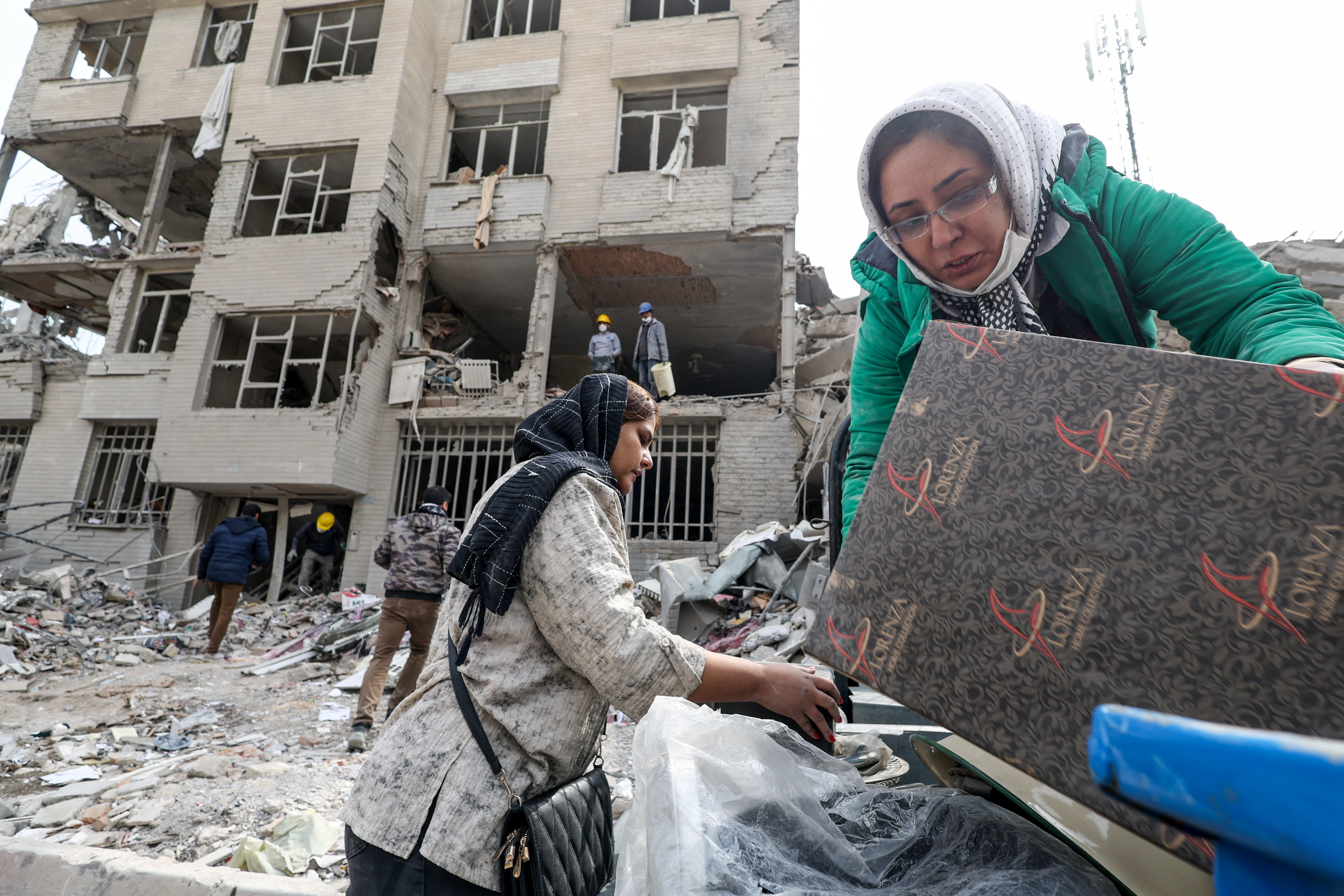 A family gathers the remaining furniture from an apartment damaged by an airstrike, amid the U.S.-Israeli conflict with Iran, in Tehran, Iran, March 12, 2026. REUTERS/Alaa Al Marjani