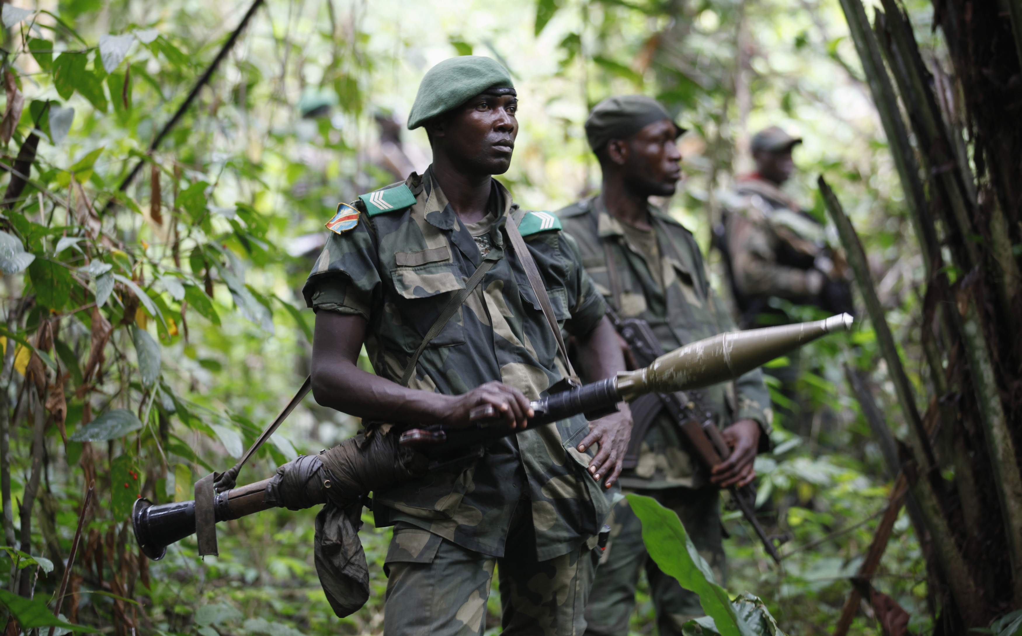 DRC soldiers carrying weapons in a forest whilst patrol against ADF rebels near Beni in North-Kivu province