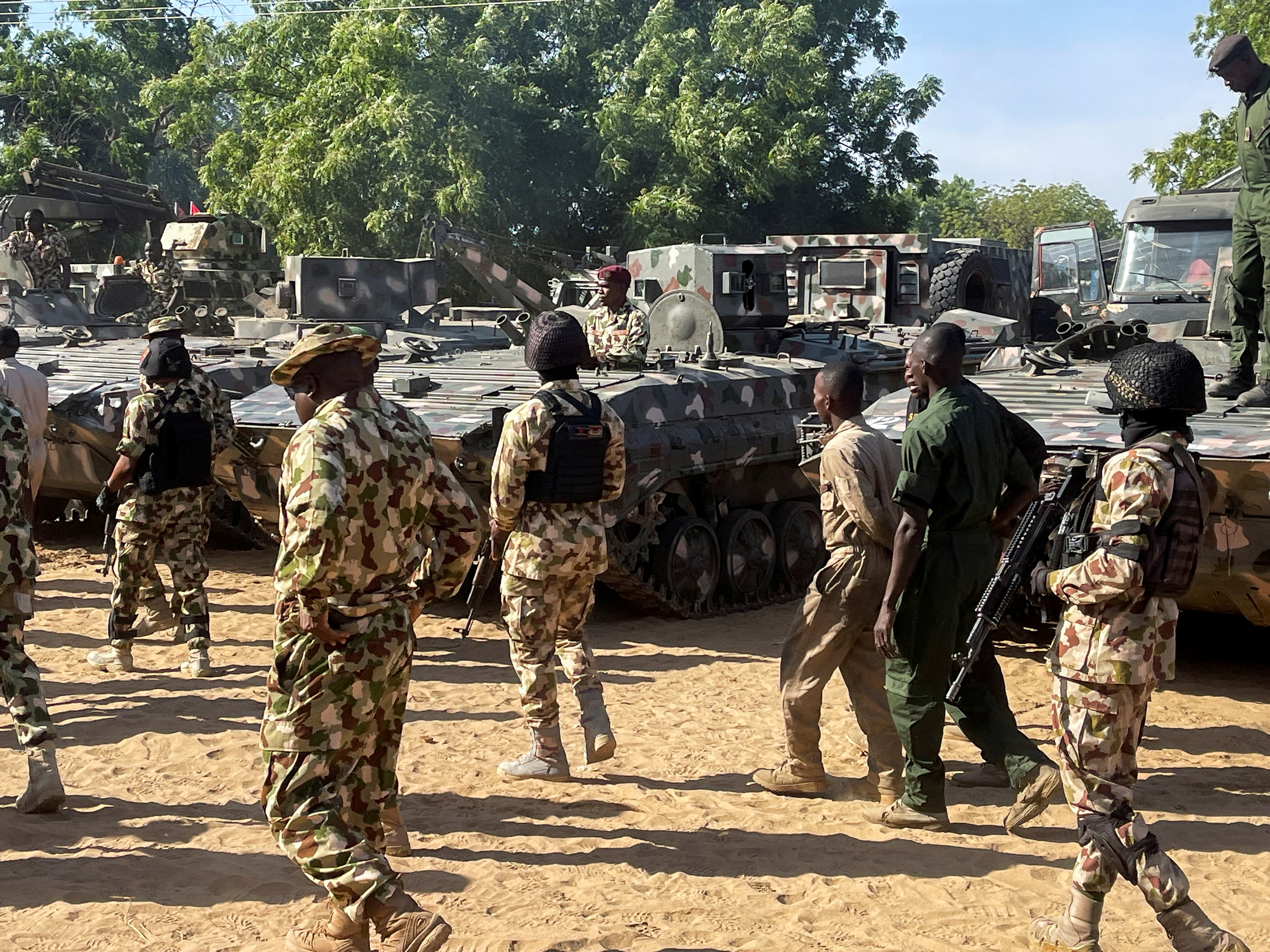 Nigerian soldiers walk past military tanks in Maiduguri, Borno State