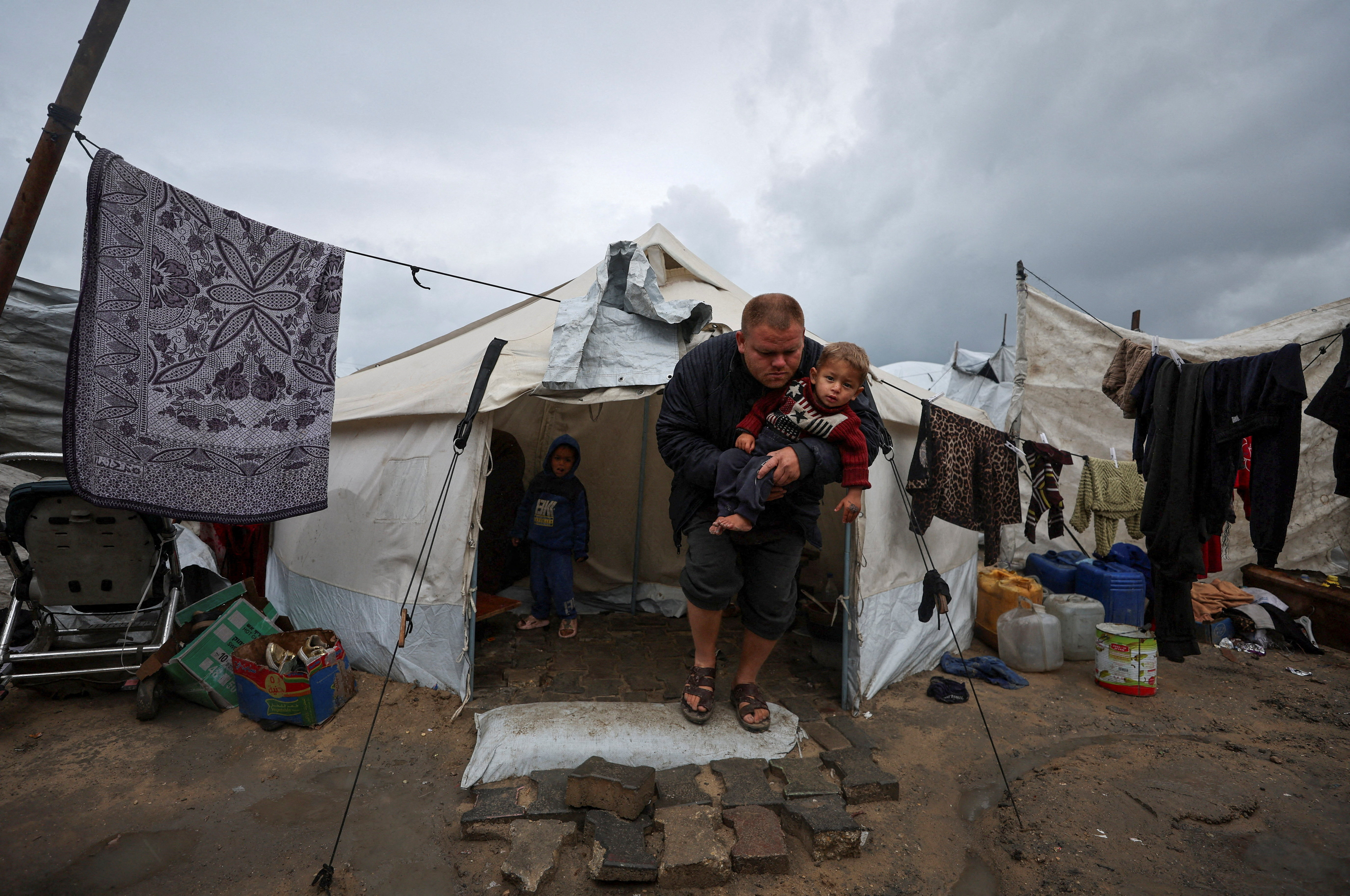 Displaced Palestinians shelter in a tent camp on a rainy day in Gaza City in March