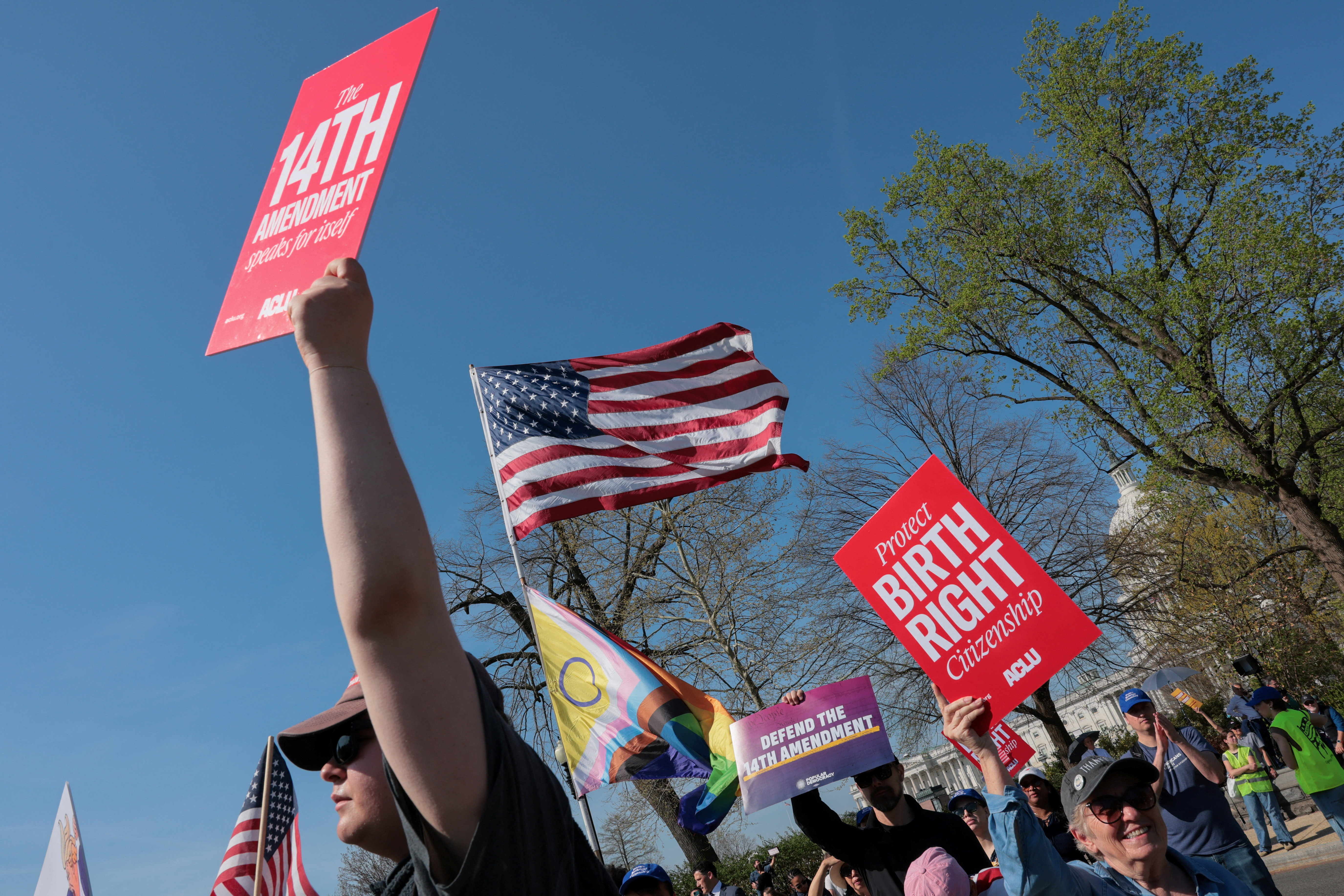 Demonstrators hold placards referencing the Fourteenth Amendment to the U.S. Constitution near the U.S. Capitol and the U.S. Supreme Court building as the court hears oral arguments on the legality of the Trump administration's effort to limit birthright citizenship for the children of immigrants, in Washington, D.C., U.S., April 1, 2026. REUTERS/Kylie Cooper