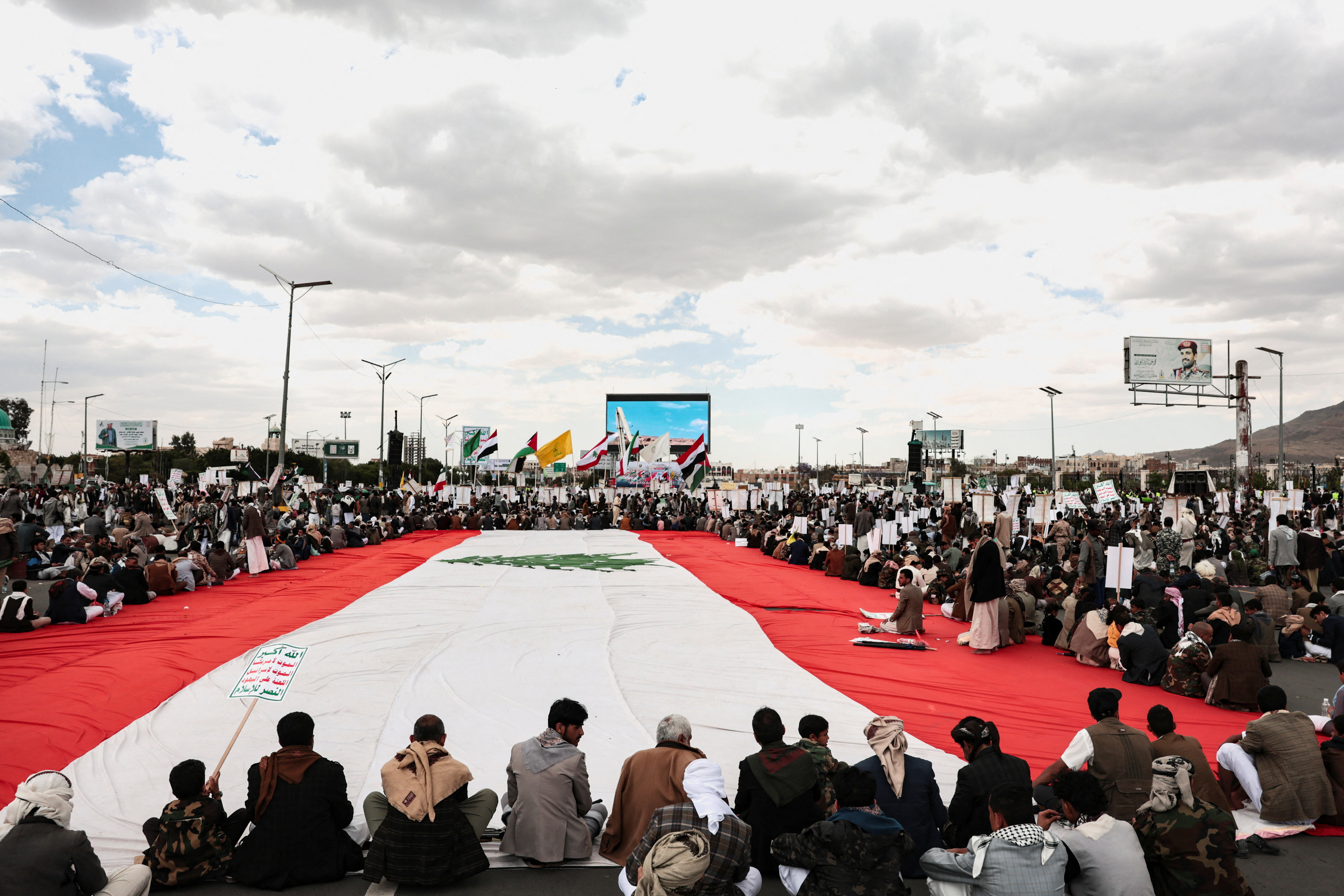 Houthi supporters in Yemen rally round a Lebanese flag during a demonstration in Sanaa to show solidarity with Lebanon [Khaled Abdullah/Reuters]