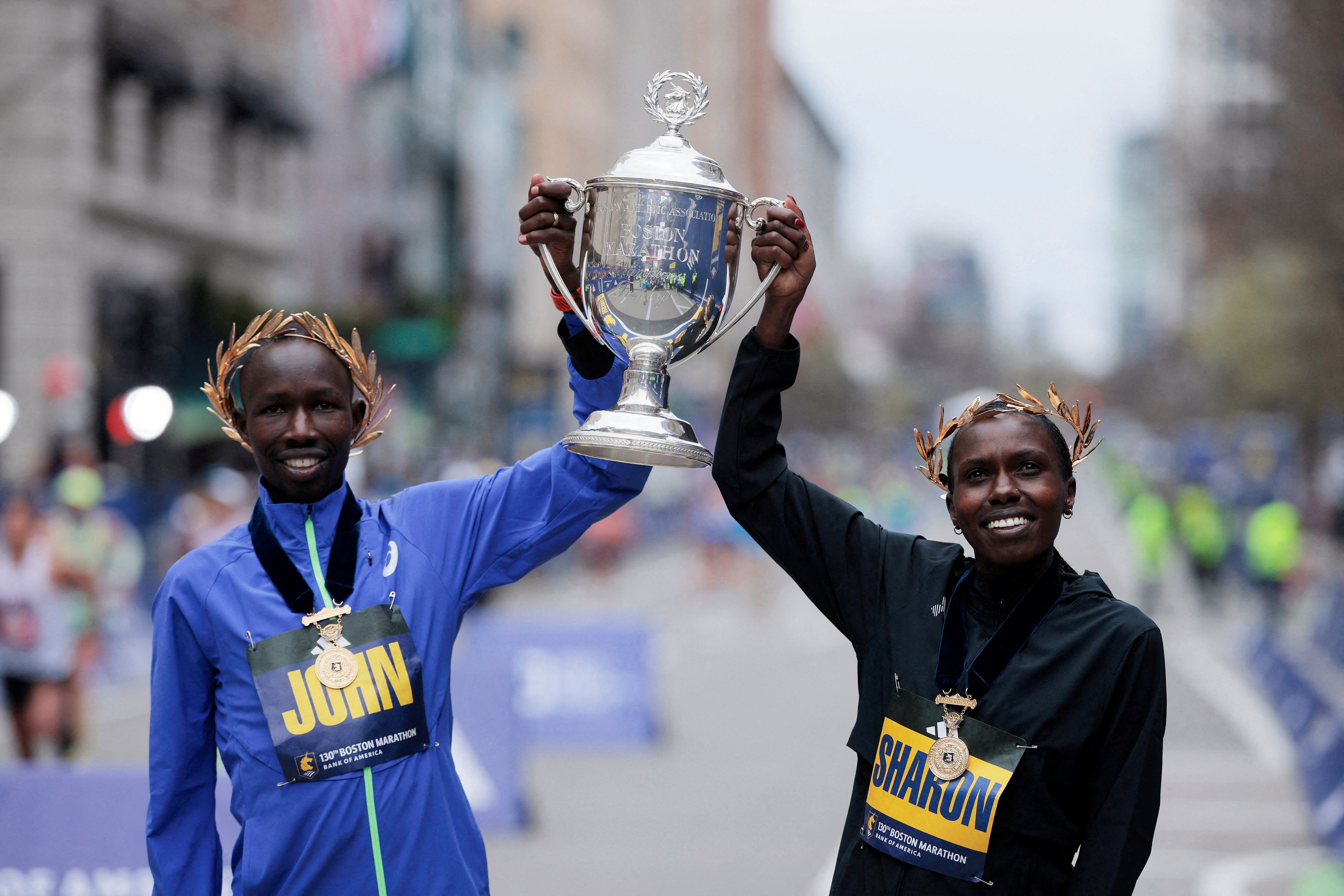 Gold medallists John Korir and Sharon Lokedi of Kenya celebrate after winning the men's and women's elite races at the Boston Marathon
