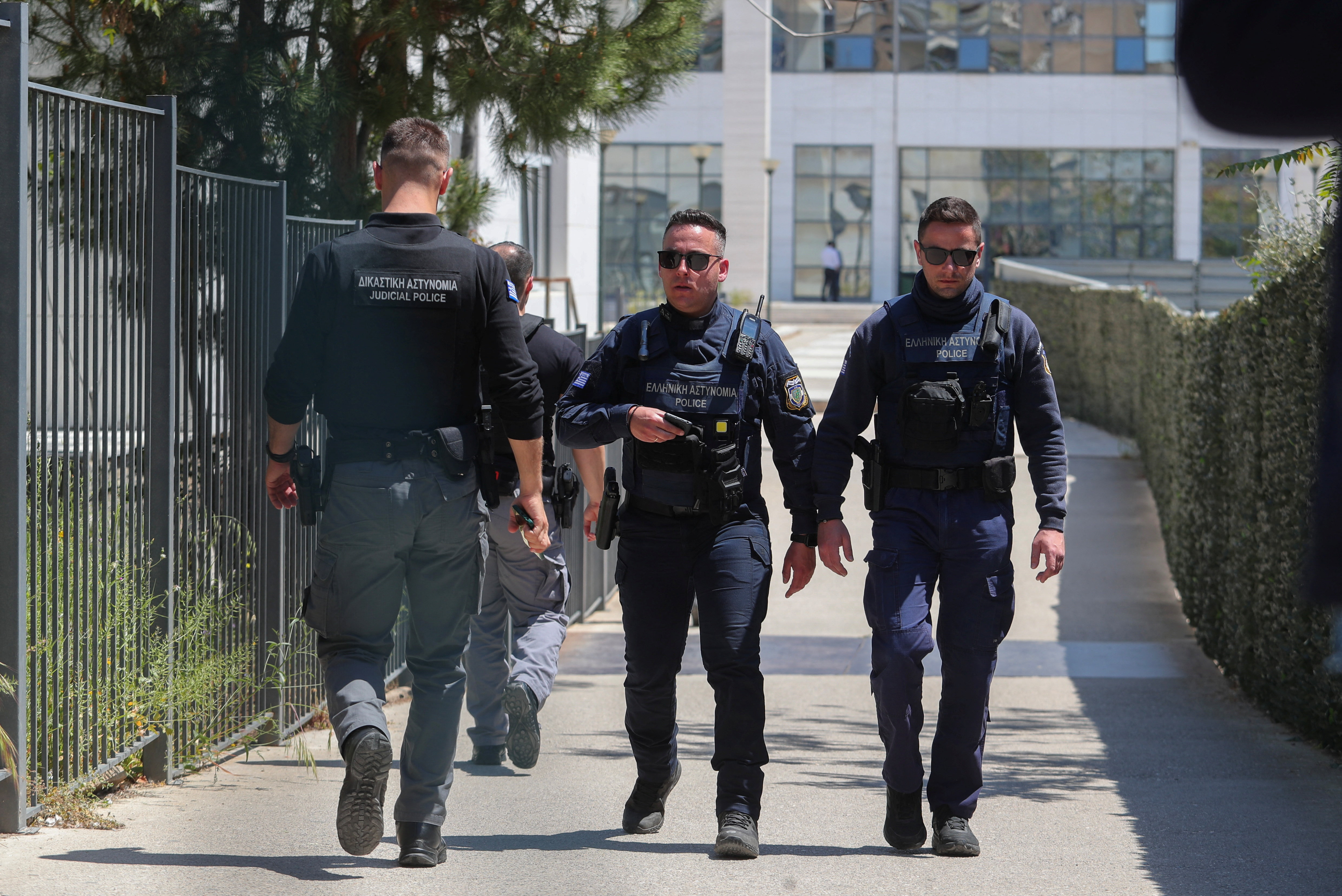 Police officers walk outside the Athens’ Court of Appeal following a shooting incident that left several wounded, in Athens, Greece