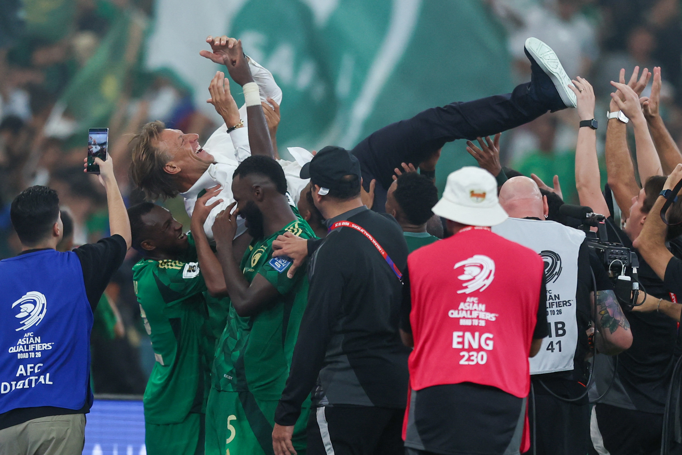 Saudi Arabia players celebrate with French coach Herve Renard during the FIFA World Cup 2026 Asian qualifier football match between Saudi Arabia and Iraq at King Abdullah Sports City in Jeddah on October 14, 2025. (Photo by Abdel Ghani BASHIR / AFP)