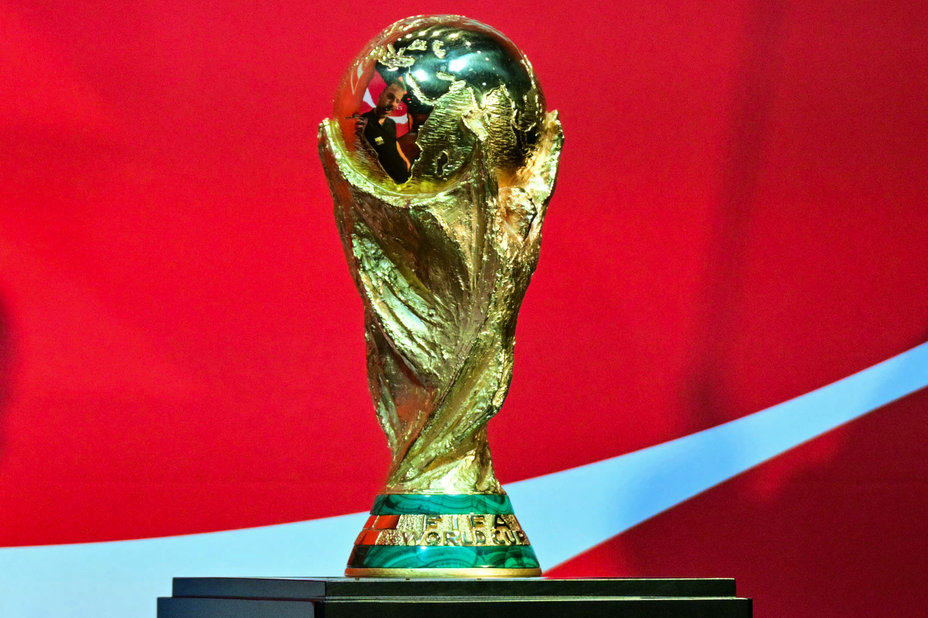 The FIFA World Cup Trophy is displayed.