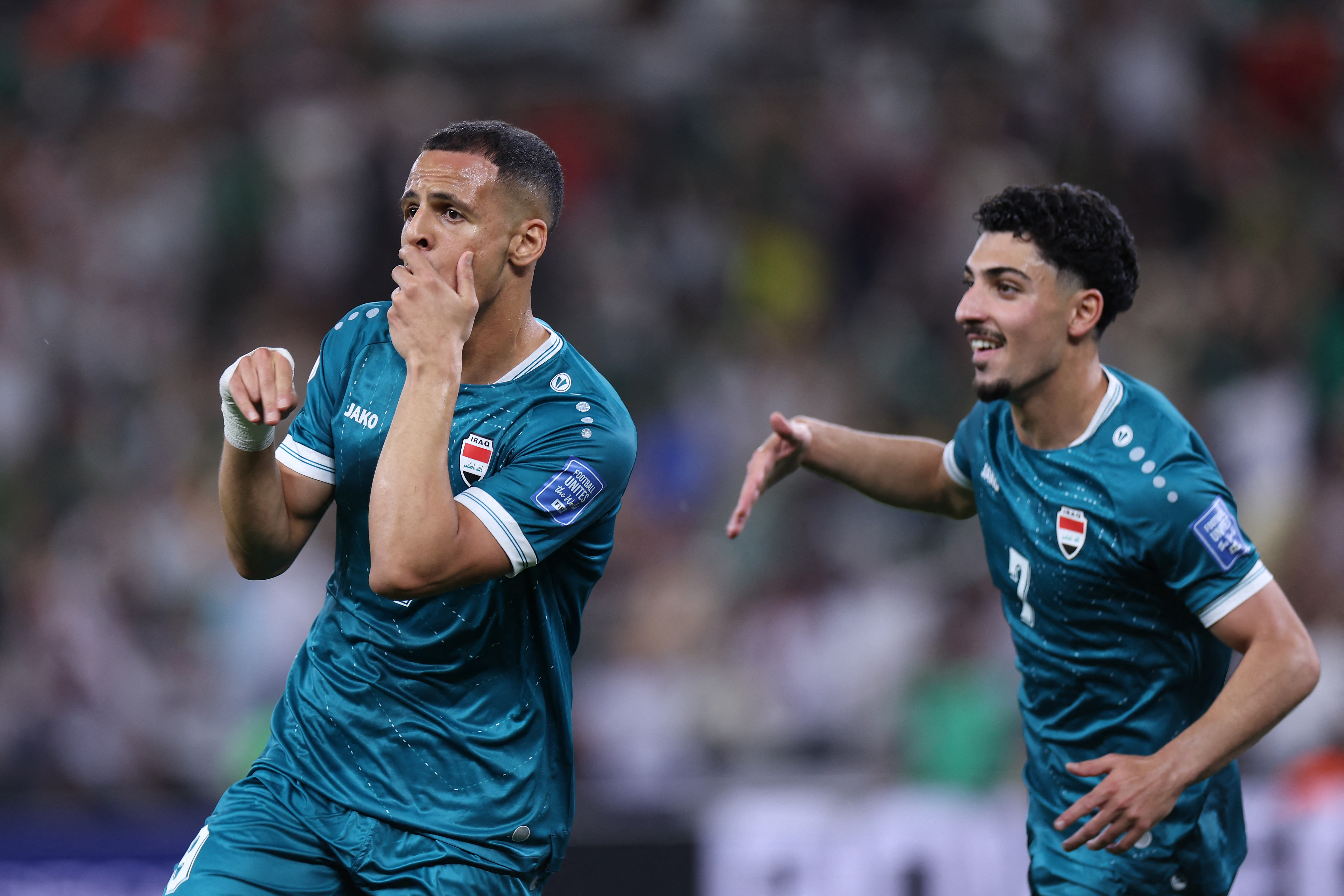 Iraq's forward #09 Ali Al-Hamadi (L) celebrates scoring his team's first goal.