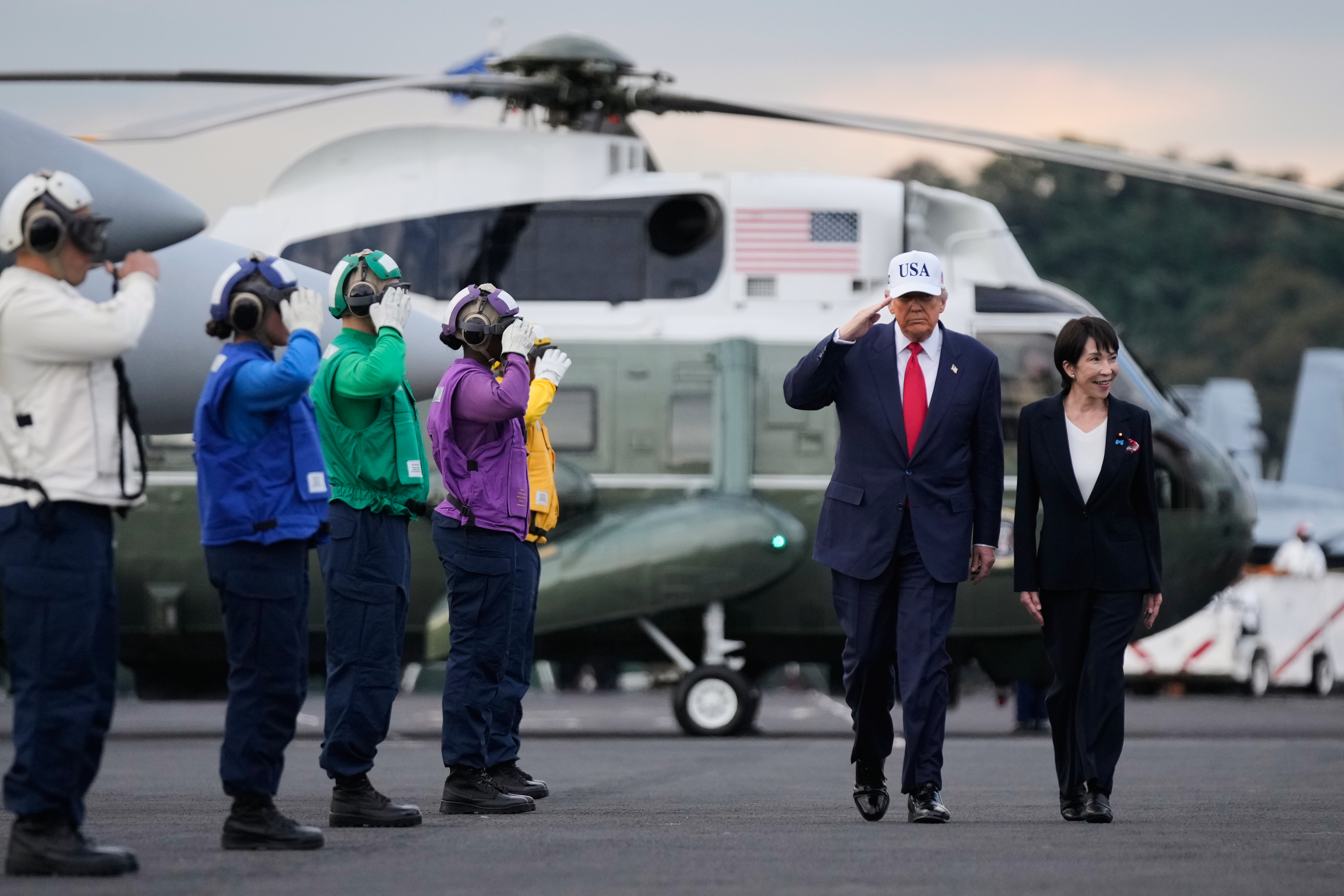 United States President Donald Trump and Japanese Prime Minister Sanae Takaichi walk on the USS George Washington, an aircraft carrier docked at a US naval base, before speaking to members of the military in Yokosuka, south of Tokyo, on October 28, 2025 [Mark Schiefelbein/AP]