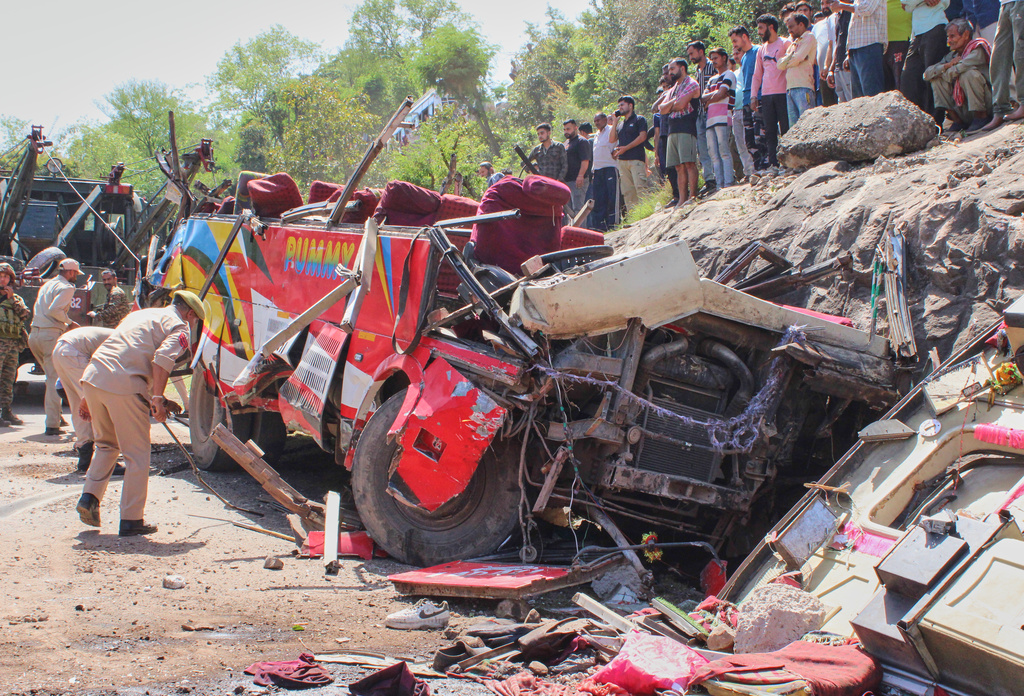 Policemen inspect the wreckage of a passenger bus after it rolled down from a hill while negotiating a blind curve near Kagort village, some 100 kilometers (62.5 miles) from Jammu, India