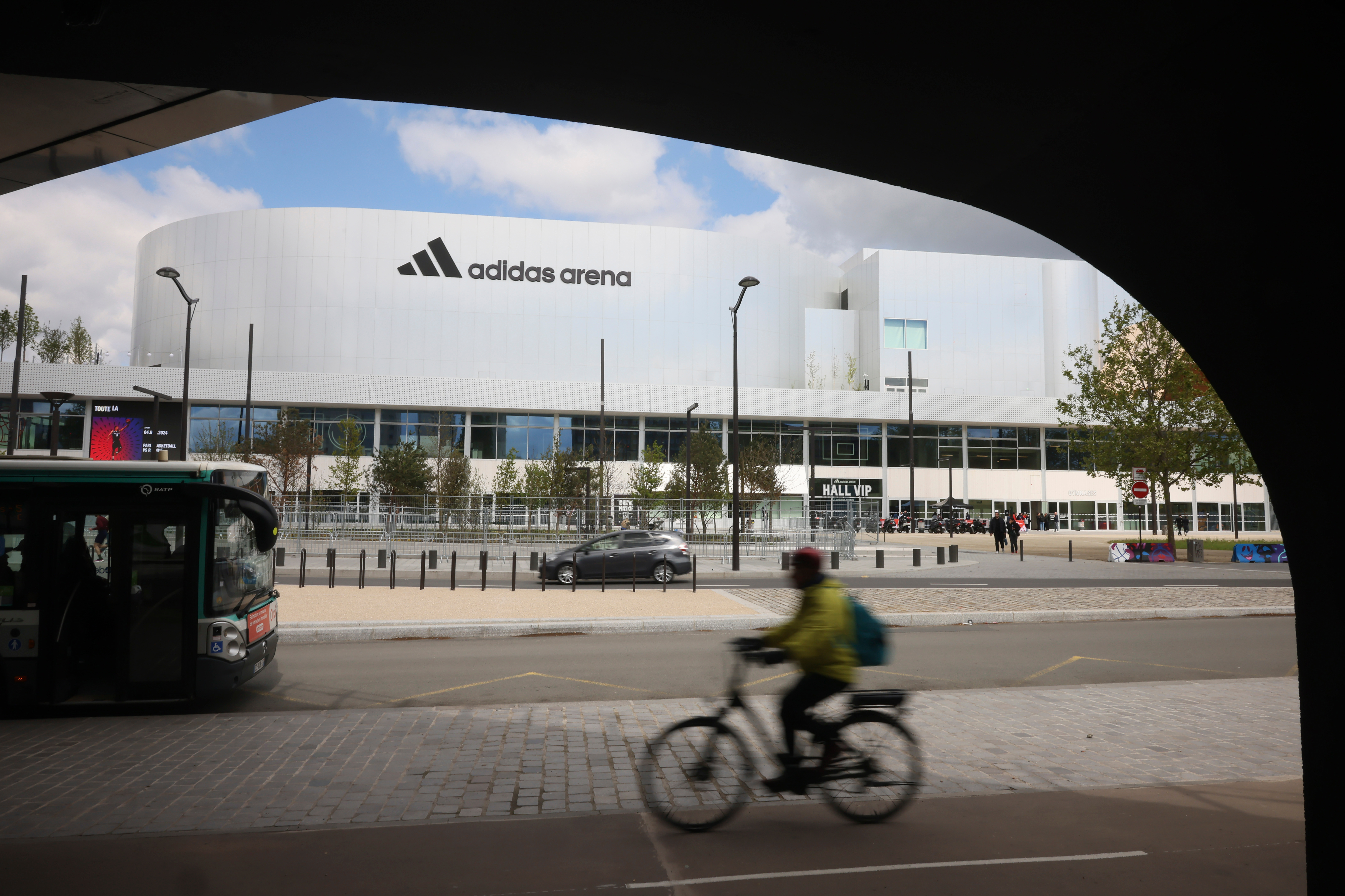 A cyclist rides past the Adidas Arena, April 18, 2024, in Paris, France