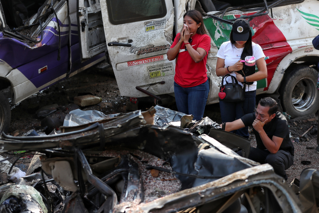 Relatives of victims pay respects at the site of an attack.