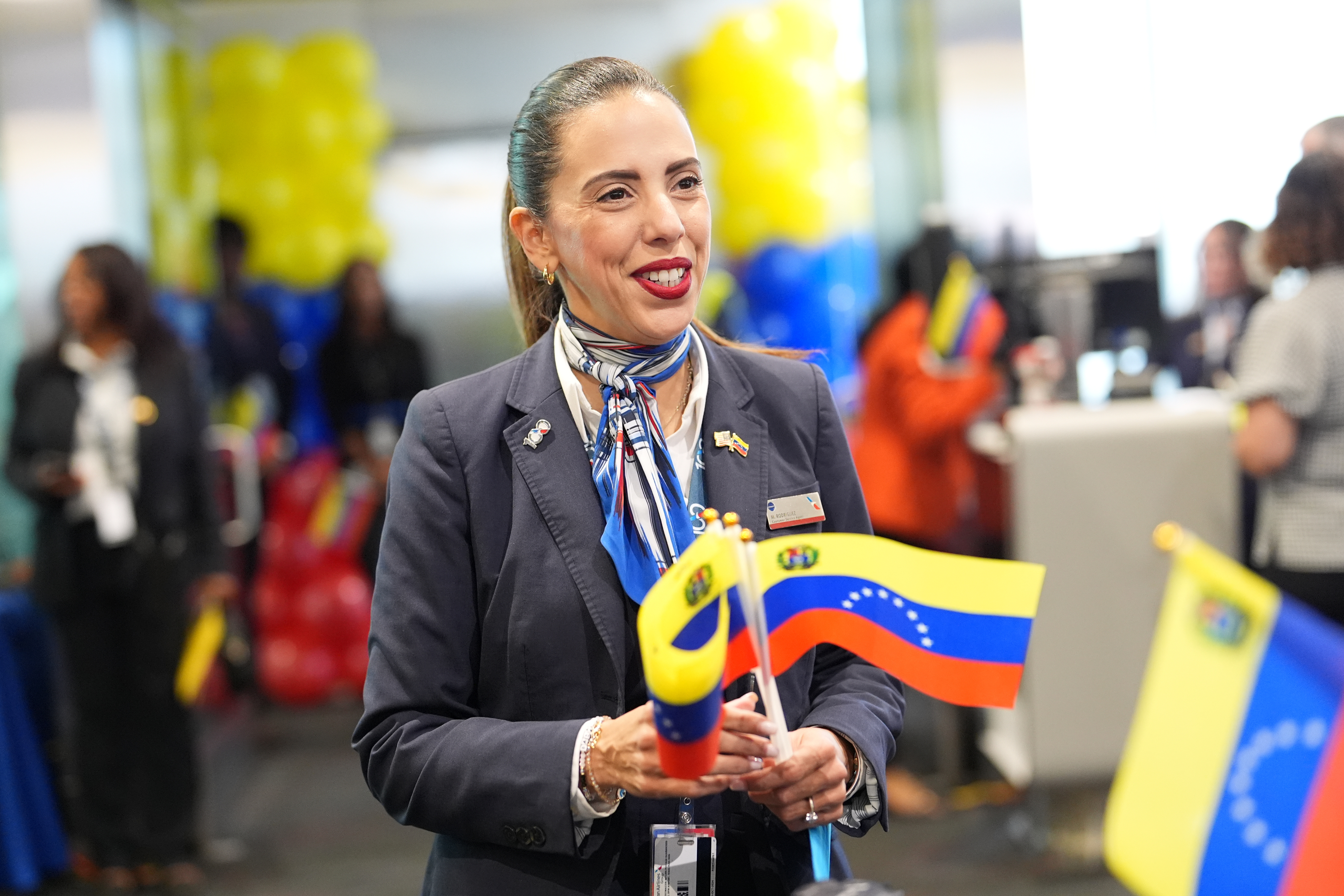An American Airlines agent holds Venezuelan flags to pass out to passengers, during boarding for Flight AA3599, the first direct commercial flight between the United States