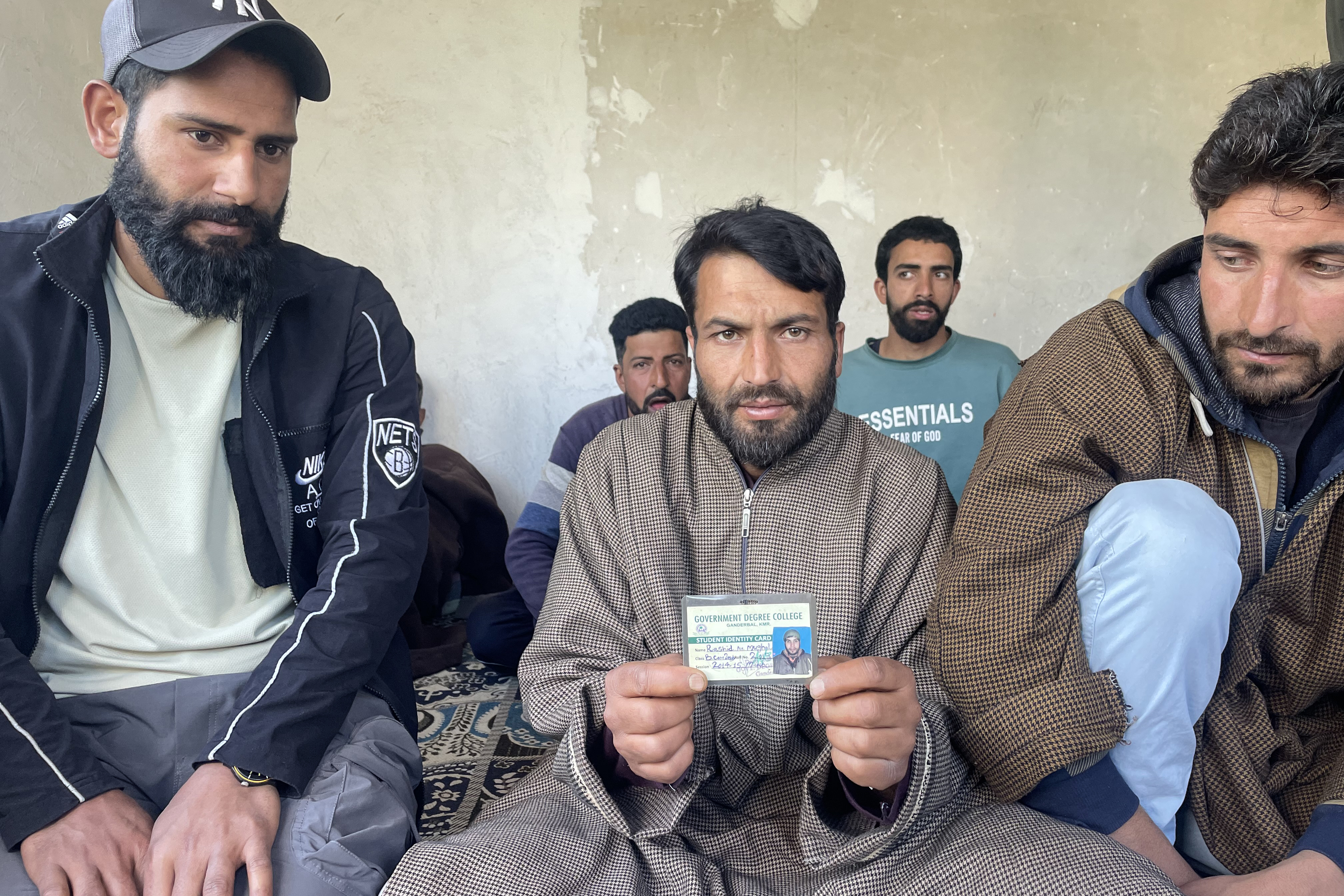 A man holds up an identity card.