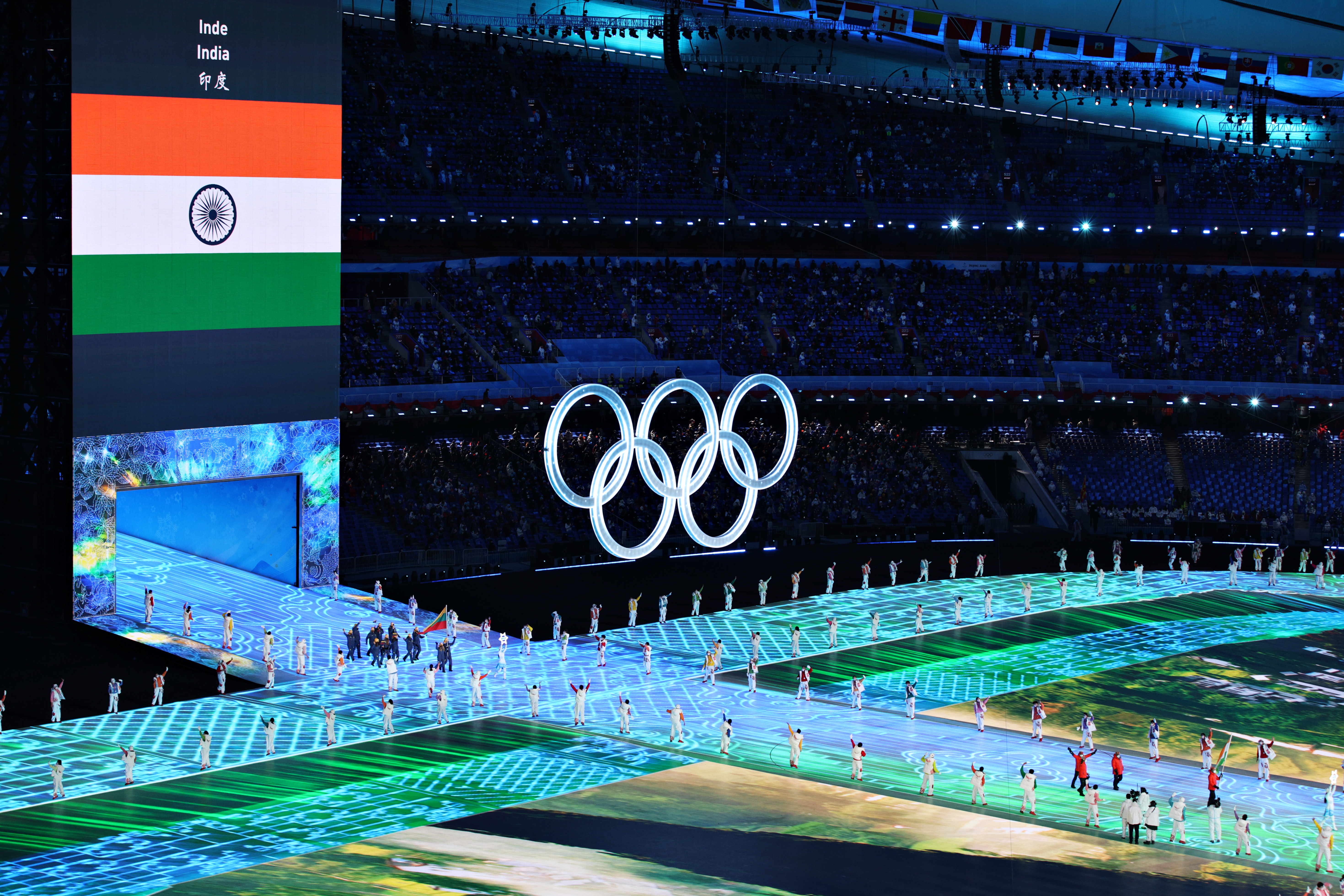 A large Olympic ring logo inside the stadium as flag bearer Arif Mohd Khan of Team India leads their team out during the opening ceremony of the Beijing Winter Olympics