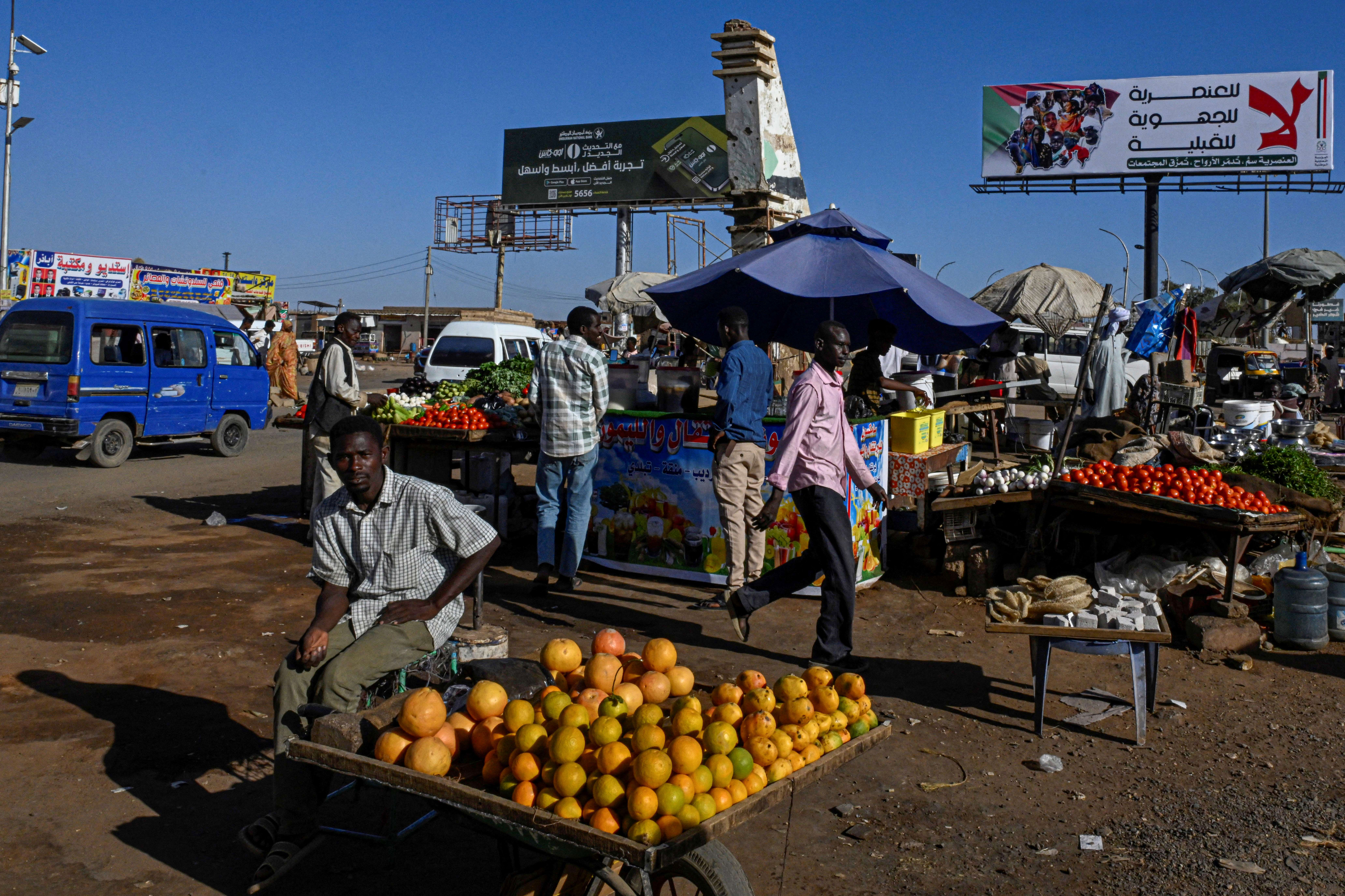 A vendor sits by a fresh produce stall at a local market in the capital Khartoum on April 16, 2026.